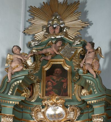 Zdjęcie nr 2: Obraz w formie stojącego prostokąta o wklęsłych górnych narożach. Święty ukazany w półpostaci, zwrócony w trzech czwartych w lewo, z głową uniesioną delikatnie w górę. W lewej ręce trzyma pałkę, a w prawej owalny medalion z wizerunkiem Chrystusa. Twarz ma o starczych rysach, z oczami patrzącymi w górę, garbatym nosem i pełnymi ustami, okoloną gęstą, krótką brodą, odwijającą się do góry oraz jasnymi, krótkimi włosami. Juda Tadeusz ubrany jest w zieloną tunikę o dużym dekolcie przepasaną w talii żółtą szarfą oraz w czerwony płaszcz przerzucony przez ramiona i spięty na piersi rzemykiem. Tło jednolite, czarne. W górnej części obrazu napis „S(anctus) Tadeus”.