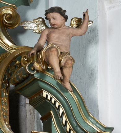 Zdjęcie nr 14: Nastawa ołtarzowa architektoniczna, jednoosiowa, jednokondygnacyjna ze zwieńczeniem, ustawiona na cokole, o lekko wklęsłym licu. Ołtarz prostopadłościenny, z drewnianą mensą. Antepedium dekorowane płyciną z monogramem Marii w wieńcu utworzonym z liści i kwiatów oraz stylizowanymi liśćmi w narożach. Nastawa ujęta parą pilastrów podtrzymujących belkowanie wyłamane na ich osi oraz odcinki falistego, przerwanego przyczółka, na którym siedzi para puttów. W polu środkowym płycina w profilowanej ramie w formie stojącego prostokąta zamkniętego łukiem odcinkowym nadwieszonym, wewnątrz obraz Matki Boskiej Różańcowej w formie stojącego prostokąta. Przed pilastrami figury św. Dominika i św. Katarzyny Sieneńskiej stojące na konsolach. Zwieńczenie w formie zbliżonej do stojącego prostokąta ujęte wolutami, zakończone faliście wygiętym gzymsem i glorią promienistą z monogramem IHS otoczonym obłokami, z główkami anielskimi i nadlatującym puttem. W polu obraz św. Józefa z Dzieciątkiem w kształcie stojącego prostokąta zamkniętego łukiem nadwieszonym półkolistym. Po bokach nastawy roślinne zwisy. Struktura polichromowana w kolorze jasnozielonym, profile oraz ornamentyka złocone.
Wewnątrz mensy napisy: „Glixelli / A. / za / Ks(iądz) Kan(onik) Aniołki / Ks(ądz) Wik(ary) Karkuli / Ks(iądz) Kat(echeta) Uczniuka / R(oku) P(ańskiego) / 1950 / Pozłotnicy z fir(my) / WIADROWSKIEGO / Najder M”.
