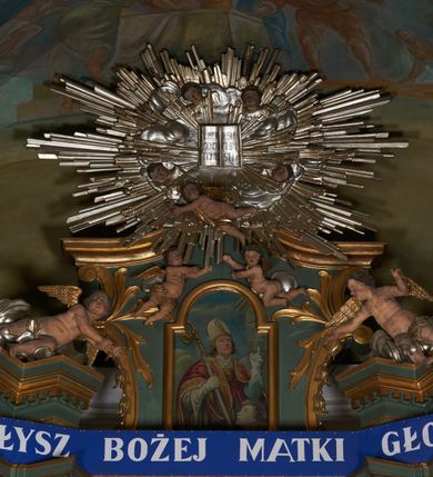 Zdjęcie nr 13: Nastawa ołtarzowa architektoniczna, jednoosiowa, jednokondygnacyjna ze zwieńczeniem, na dwustrefowym cokole. Ołtarz prostopadłościenny, mensa marmurowa z portatylem. Antepedium w formie leżącego prostokąta ujęte płyciną z monogramem Marii w akantowym wieńcu w centrum, w narożach rocaille. Retabulum ujęte parą filarów dźwigających pełne belkowanie przerwane nad polem środkowym, wyłamane partie podtrzymywane przez rokokowe konsole z uskrzydlonymi główkami anielskimi i kartuszami. Na belkowaniu zdwojony przerwany przyczółek z puttami. W polu środkowym obraz Matki Boskiej Niepokalanie Poczętej ujęty profilowaną ramą w formie stojącego prostokąta, zamkniętego łukiem nadwieszonym z uskokiem. Z dwóch stron filarów cztery figury ewangelistów ustawione na konsolach. Zwieńczenie w formie stojącego prostokąta, ujęte spływami wolutowymi, zamknięte fragmentem falistego gzymsu oraz glorią promienistą z otwartą księgą z napisem: „LIBER GENERTIONIS / JESU CHRISTI” pośród obłoków i główek anielskich oraz figurek puttów. W polu obraz św. Stanisława w formie stojącego prostokąta zamkniętego półkolistym łukiem nadwieszonym. Nastawa ujęta uszami utworzonymi z rocaille'u i róż. Struktura ołtarza polichromowana w kolorze jasnozielonym, z pozłacanymi profilami i ornamentyką oraz posrebrzoną glorią i detalami.