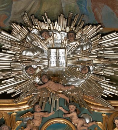 Zdjęcie nr 15: Nastawa ołtarzowa architektoniczna, jednoosiowa, jednokondygnacyjna ze zwieńczeniem, na dwustrefowym cokole. Ołtarz prostopadłościenny, mensa marmurowa z portatylem. Antepedium w formie leżącego prostokąta ujęte płyciną z monogramem Marii w akantowym wieńcu w centrum, w narożach rocaille. Retabulum ujęte parą filarów dźwigających pełne belkowanie przerwane nad polem środkowym, wyłamane partie podtrzymywane przez rokokowe konsole z uskrzydlonymi główkami anielskimi i kartuszami. Na belkowaniu zdwojony przerwany przyczółek z puttami. W polu środkowym obraz Matki Boskiej Niepokalanie Poczętej ujęty profilowaną ramą w formie stojącego prostokąta, zamkniętego łukiem nadwieszonym z uskokiem. Z dwóch stron filarów cztery figury ewangelistów ustawione na konsolach. Zwieńczenie w formie stojącego prostokąta, ujęte spływami wolutowymi, zamknięte fragmentem falistego gzymsu oraz glorią promienistą z otwartą księgą z napisem: „LIBER GENERTIONIS / JESU CHRISTI” pośród obłoków i główek anielskich oraz figurek puttów. W polu obraz św. Stanisława w formie stojącego prostokąta zamkniętego półkolistym łukiem nadwieszonym. Nastawa ujęta uszami utworzonymi z rocaille&#039;u i róż. Struktura ołtarza polichromowana w kolorze jasnozielonym, z pozłacanymi profilami i ornamentyką oraz posrebrzoną glorią i detalami.