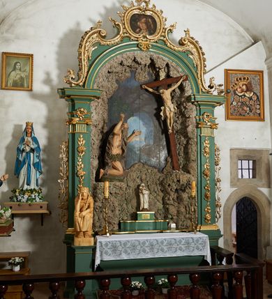 Zdjęcie nr 3: Ołtarz architektoniczny, jednoosiowy, jednokondygnacyjny ze zwieńczeniem. Pierwsza kondygnacja w formie arkady, flankowana parą zdwojonych pilastrów dźwigających imposty i półkolistą profilowaną archiwoltę, ujętą spływami wolutowymi utworzonymi z rocaille'u. Pilastry dekorowane różanymi gałązkami, uszy utworzone z analogicznego motywu. Zwieńczenie w formie rocaille'owego kartusza z obrazem św. Sebastiana. W arkadzie rzeźbiona grota z figurą św. Onufrego przed krucyfiksem. Tło malowane z przedstawieniem wnętrza groty oraz prześwitu z górskim krajobrazem. Polichromia ołtarza jasnozielona z pozłacanymi profilami i ornamentyką.