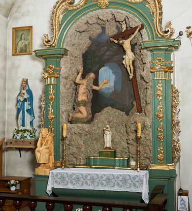 Zdjęcie nr 2: Ołtarz architektoniczny, jednoosiowy, jednokondygnacyjny ze zwieńczeniem. Pierwsza kondygnacja w formie arkady, flankowana parą zdwojonych pilastrów dźwigających imposty i półkolistą profilowaną archiwoltę, ujętą spływami wolutowymi utworzonymi z rocaille&#039;u. Pilastry dekorowane różanymi gałązkami, uszy utworzone z analogicznego motywu. Zwieńczenie w formie rocaille&#039;owego kartusza z obrazem św. Sebastiana. W arkadzie rzeźbiona grota z figurą św. Onufrego przed krucyfiksem. Tło malowane z przedstawieniem wnętrza groty oraz prześwitu z górskim krajobrazem. Polichromia ołtarza jasnozielona z pozłacanymi profilami i ornamentyką.