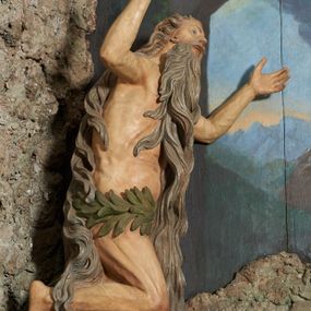 Zdjęcie nr 1: W polu ołtarza imitującego grotę skalną znajduje się figura św. Onufrego modlącego się przed krucyfiksem. Po lewej stronie pełnoplastyczna figura klęczącego świętego ukazanego z profilu, z uniesionymi wysoko obiema rękami i głową. Twarz o starczych rysach, zwróconych w górę oczach, dużym nosie i otwartych ustach z widocznym uzębieniem, okolona bardzo długą, siwą brodą w postaci falowanych pasm, sięgających ziemi. Włosy siwe, zmierzwione, opadają na plecy w formie długich skręconych pasm, sięgających stóp. Ciało szczupłe, plastyczne modelowane, o wyraźnie zarysowanej anatomii i starczych cechach. Biodra przepasane liściastą gałązką. 
Polichromia naturalistyczna.