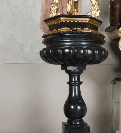 Zdjęcie nr 1: Chrzcielnica została osadzona na trójstopniowej, schodkowo zmniejszającej się, kwadratowej w rzucie podstawie. Jest utworzona z trzonu w typie gruszkowatym, który podtrzymuje płytką czarę, silnie wybrzuszoną w dolnej części, z puklami i lekko wklęsłą w górnej z profilowanym, zaoblonym brzegiem. Pokrywa drewniana,  sześcioboczna, zwieńczona czterema liściastymi, wolutowymi kabłąkami z kulą i krzyżem na szczycie. Na podstawie ryta inskrypcja:  "A[NDREAS] M[AJERANOWSKI] / PH[ILOSOPHIAE] D[OCTOR] / P[AROCHUS] G[IEBULTOVIENSIS] / D[EO] S[ACRUM] / A[NNO] D[OMINI] / 1666".