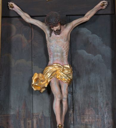 Zdjęcie nr 3: Ołtarz przyścienny, architektoniczny, jednoosiowy, jednokondygnacyjny. Ołtarz prostopadłościenny, skrzyniowy, mensa drewniana z kamiennym portatylem. Antepedium zdobione prostokątną płyciną o wklęsłych narożach, w której rzeźbiona uskrzydlona główka anielska. Retabulum ujęte parą kolumn, ustawionych na bazach. Trzony kolumn dekorowane w jednej trzeciej wysokości ornamentem okuciowym z rautami i kaboszonami, powyżej przewiązane opaską i zdobione w górnej części płaskorzeźbioną wicią winorośli. Powyżej kapiteli ustawione wazony wspierające wyłamane ponad nimi belkowanie z  trójkątnym, przerwanym przyczółkiem.  Pośrodku zwieńczenia pełnoplastyczna figura uskrzydlonego putta stojąca na kartuszu. Nastawa po bokach dekorowana ażurowymi, wąskimi uszakami formowanymi ze splotów z akantu i ornamentu rocaille'owego. Fryz zdobiony rzeźbioną wicią roślinną z rozetami. Pole środkowe w formie prostokątnej wnęki o wklęsłych górnych narożach, ujętej profilowaną ramą; wewnątrz rzeźbiony krucyfiks na malowanym tle Jerozolimy. Całość struktury ołtarza polichromowana w odcieniu jasnego beżu, detal architektoniczny, ornamentyka i profilowania złocone; pole kartusza i szata aniołka srebrzone.

