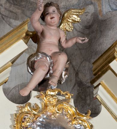 Zdjęcie nr 6: Ołtarz przyścienny, architektoniczny, jednoosiowy, jednokondygnacyjny. Ołtarz prostopadłościenny, skrzyniowy, mensa drewniana z kamiennym portatylem. Antepedium zdobione prostokątną płyciną o wklęsłych narożach, w której rzeźbiona uskrzydlona główka anielska. Retabulum ujęte parą kolumn, ustawionych na bazach. Trzony kolumn dekorowane w jednej trzeciej wysokości ornamentem okuciowym z rautami i kaboszonami, powyżej przewiązane opaską i zdobione w górnej części płaskorzeźbioną wicią winorośli. Powyżej kapiteli ustawione wazony wspierające wyłamane ponad nimi belkowanie z  trójkątnym, przerwanym przyczółkiem.  Pośrodku zwieńczenia pełnoplastyczna figura uskrzydlonego putta stojąca na kartuszu. Nastawa po bokach dekorowana ażurowymi, wąskimi uszakami formowanymi ze splotów z akantu i ornamentu rocaille&#039;owego. Fryz zdobiony rzeźbioną wicią roślinną z rozetami. Pole środkowe w formie prostokątnej wnęki o wklęsłych górnych narożach, ujętej profilowaną ramą; wewnątrz rzeźbiony krucyfiks na malowanym tle Jerozolimy. Całość struktury ołtarza polichromowana w odcieniu jasnego beżu, detal architektoniczny, ornamentyka i profilowania złocone; pole kartusza i szata aniołka srebrzone.

