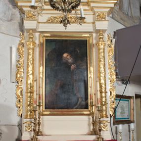 Zdjęcie nr 1: Ołtarz przyścienny, architektoniczny, jednoosiowy, jednokondygnacyjny. Ołtarz prostopadłościenny, skrzyniowy, mensa drewniana z kamiennym portatylem. Antepedium zdobione prostokątną płyciną o wklęsłych narożach, w której rzeźbiona uskrzydlona główka anielska. Retabulum ujęte parą kolumn, ustawionych na bazach. Trzony kolumn dekorowane w jednej trzeciej wysokości ornamentem okuciowym z rautami i kaboszonami, powyżej przewiązane opaską i zdobione w górnej części płaskorzeźbioną wicią winorośli. Powyżej kapiteli ustawione wazony wspierające wyłamane ponad nimi belkowanie z  trójkątnym, przerwanym przyczółkiem.  Pośrodku zwieńczenia pełnoplastyczna figura uskrzydlonego putta stojąca na kartuszu. Nastawa po bokach dekorowana ażurowymi, wąskimi uszakami formowanymi ze splotów z akantu i ornamentu rocaille'owego. Fryz zdobiony rzeźbioną wicią roślinną z rozetami. Pole środkowe w formie prostokątnej wnęki ujętej profilowaną ramą; wewnątrz obraz z przedstawieniem św. Idziego. Całość struktury ołtarza polichromowana w odcieniu jasnego beżu, detal architektoniczny, ornamentyka i profilowania złocone; pole kartusza i szata aniołka srebrzone.