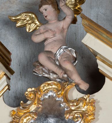 Zdjęcie nr 6: Ołtarz przyścienny, architektoniczny, jednoosiowy, jednokondygnacyjny. Ołtarz prostopadłościenny, skrzyniowy, mensa drewniana z kamiennym portatylem. Antepedium zdobione prostokątną płyciną o wklęsłych narożach, w której rzeźbiona uskrzydlona główka anielska. Retabulum ujęte parą kolumn, ustawionych na bazach. Trzony kolumn dekorowane w jednej trzeciej wysokości ornamentem okuciowym z rautami i kaboszonami, powyżej przewiązane opaską i zdobione w górnej części płaskorzeźbioną wicią winorośli. Powyżej kapiteli ustawione wazony wspierające wyłamane ponad nimi belkowanie z  trójkątnym, przerwanym przyczółkiem.  Pośrodku zwieńczenia pełnoplastyczna figura uskrzydlonego putta stojąca na kartuszu. Nastawa po bokach dekorowana ażurowymi, wąskimi uszakami formowanymi ze splotów z akantu i ornamentu rocaille'owego. Fryz zdobiony rzeźbioną wicią roślinną z rozetami. Pole środkowe w formie prostokątnej wnęki ujętej profilowaną ramą; wewnątrz obraz z przedstawieniem św. Idziego. Całość struktury ołtarza polichromowana w odcieniu jasnego beżu, detal architektoniczny, ornamentyka i profilowania złocone; pole kartusza i szata aniołka srebrzone.