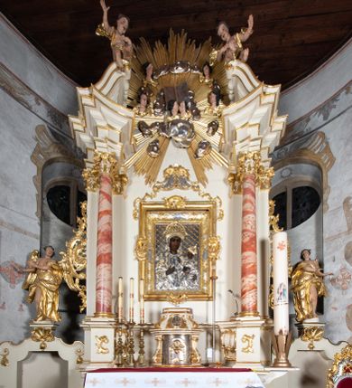 Zdjęcie nr 1: Nastawa ołtarzowa architektoniczna, jednoosiowa, jednokondygnacyjna ze zwieńczeniem z bramkami. Bramki z przejściami w formie stojącego prostokąta, zwieńczone fantazyjnym łukiem ujętym spływami wolutowymi, zakończonymi cokołami z figurami aniołów. Ołtarz kamienny w drewnianej obudowie z drewnianą mensą. Antepedium w formie leżącego prostokąta w profilowanej ramie, podzielone na pięć pól, w środkowym aplikowany monogram maryjny. Tabernakulum o wypukłej ścianie frontowej, ujęte w narożach ukośnie dostawionymi pilastrami o trzonach utworzonych z wolut. Drzwiczki w formie stojącego prostokąta zamkniętego łukiem wklęsło-wypukłym z uskokiem; w polu kielich z hostią w glorii. Tron wystawienia w formie zwężającego się ku górze cokołu o ściętych narożach, ujętych spływami wolutowymi. Z przodu owalny kartusz z monogramem IHS. Kondygnacja ustawiona na zdwojonym cokole, ujęta parą zwielokrotnionych pilastrów i parą kolumn wysuniętych do przodu o kapitelach kompozytowych, dźwigających imposty zwrócone do wewnątrz ołtarza oraz przerwany falisty przyczółek z siedzącą parą puttów. W polu środkowym profilowana rama w kształcie stojącego prostokąta z obrazem Matki Boskiej Częstochowskiej, na zasuwie obraz „Najświętsze Serce Jezusa”. Zwieńczenie w formie promienistej  glorii. W polu obłoki z otwartą księgą i uskrzydlonymi główkami anielskimi. Kondygnacja ujęta uszami utworzonymi z ażurowego ornamentu rocaille'owego z elementami wstęgi. Struktura polichromowana w kolorze beżowym, kolumny marmoryzowane w kolorze różowo-czerwonym, detale i ornamentyka złocone oraz srebrzone.