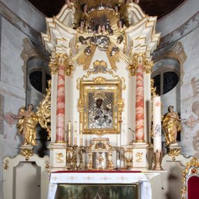 Zdjęcie nr 1: Nastawa ołtarzowa architektoniczna, jednoosiowa, jednokondygnacyjna ze zwieńczeniem z bramkami. Bramki z przejściami w formie stojącego prostokąta, zwieńczone fantazyjnym łukiem ujętym spływami wolutowymi, zakończonymi cokołami z figurami aniołów. Ołtarz kamienny w drewnianej obudowie z drewnianą mensą. Antepedium w formie leżącego prostokąta w profilowanej ramie, podzielone na pięć pól, w środkowym aplikowany monogram maryjny. Tabernakulum o wypukłej ścianie frontowej, ujęte w narożach ukośnie dostawionymi pilastrami o trzonach utworzonych z wolut. Drzwiczki w formie stojącego prostokąta zamkniętego łukiem wklęsło-wypukłym z uskokiem; w polu kielich z hostią w glorii. Tron wystawienia w formie zwężającego się ku górze cokołu o ściętych narożach, ujętych spływami wolutowymi. Z przodu owalny kartusz z monogramem IHS. Kondygnacja ustawiona na zdwojonym cokole, ujęta parą zwielokrotnionych pilastrów i parą kolumn wysuniętych do przodu o kapitelach kompozytowych, dźwigających imposty zwrócone do wewnątrz ołtarza oraz przerwany falisty przyczółek z siedzącą parą puttów. W polu środkowym profilowana rama w kształcie stojącego prostokąta z obrazem Matki Boskiej Częstochowskiej, na zasuwie obraz „Najświętsze Serce Jezusa”. Zwieńczenie w formie promienistej  glorii. W polu obłoki z otwartą księgą i uskrzydlonymi główkami anielskimi. Kondygnacja ujęta uszami utworzonymi z ażurowego ornamentu rocaille'owego z elementami wstęgi. Struktura polichromowana w kolorze beżowym, kolumny marmoryzowane w kolorze różowo-czerwonym, detale i ornamentyka złocone oraz srebrzone.