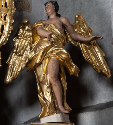 Zdjęcie nr 3: Nastawa ołtarzowa architektoniczna, jednoosiowa, jednokondygnacyjna ze zwieńczeniem z bramkami. Bramki z przejściami w formie stojącego prostokąta, zwieńczone fantazyjnym łukiem ujętym spływami wolutowymi, zakończonymi cokołami z figurami aniołów. Ołtarz kamienny w drewnianej obudowie z drewnianą mensą. Antepedium w formie leżącego prostokąta w profilowanej ramie, podzielone na pięć pól, w środkowym aplikowany monogram maryjny. Tabernakulum o wypukłej ścianie frontowej, ujęte w narożach ukośnie dostawionymi pilastrami o trzonach utworzonych z wolut. Drzwiczki w formie stojącego prostokąta zamkniętego łukiem wklęsło-wypukłym z uskokiem; w polu kielich z hostią w glorii. Tron wystawienia w formie zwężającego się ku górze cokołu o ściętych narożach, ujętych spływami wolutowymi. Z przodu owalny kartusz z monogramem IHS. Kondygnacja ustawiona na zdwojonym cokole, ujęta parą zwielokrotnionych pilastrów i parą kolumn wysuniętych do przodu o kapitelach kompozytowych, dźwigających imposty zwrócone do wewnątrz ołtarza oraz przerwany falisty przyczółek z siedzącą parą puttów. W polu środkowym profilowana rama w kształcie stojącego prostokąta z obrazem Matki Boskiej Częstochowskiej, na zasuwie obraz „Najświętsze Serce Jezusa”. Zwieńczenie w formie promienistej  glorii. W polu obłoki z otwartą księgą i uskrzydlonymi główkami anielskimi. Kondygnacja ujęta uszami utworzonymi z ażurowego ornamentu rocaille'owego z elementami wstęgi. Struktura polichromowana w kolorze beżowym, kolumny marmoryzowane w kolorze różowo-czerwonym, detale i ornamentyka złocone oraz srebrzone.