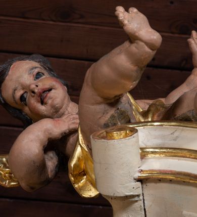 Zdjęcie nr 25: Nastawa ołtarzowa architektoniczna, jednoosiowa, jednokondygnacyjna ze zwieńczeniem z bramkami. Bramki z przejściami w formie stojącego prostokąta, zwieńczone fantazyjnym łukiem ujętym spływami wolutowymi, zakończonymi cokołami z figurami aniołów. Ołtarz kamienny w drewnianej obudowie z drewnianą mensą. Antepedium w formie leżącego prostokąta w profilowanej ramie, podzielone na pięć pól, w środkowym aplikowany monogram maryjny. Tabernakulum o wypukłej ścianie frontowej, ujęte w narożach ukośnie dostawionymi pilastrami o trzonach utworzonych z wolut. Drzwiczki w formie stojącego prostokąta zamkniętego łukiem wklęsło-wypukłym z uskokiem; w polu kielich z hostią w glorii. Tron wystawienia w formie zwężającego się ku górze cokołu o ściętych narożach, ujętych spływami wolutowymi. Z przodu owalny kartusz z monogramem IHS. Kondygnacja ustawiona na zdwojonym cokole, ujęta parą zwielokrotnionych pilastrów i parą kolumn wysuniętych do przodu o kapitelach kompozytowych, dźwigających imposty zwrócone do wewnątrz ołtarza oraz przerwany falisty przyczółek z siedzącą parą puttów. W polu środkowym profilowana rama w kształcie stojącego prostokąta z obrazem Matki Boskiej Częstochowskiej, na zasuwie obraz „Najświętsze Serce Jezusa”. Zwieńczenie w formie promienistej  glorii. W polu obłoki z otwartą księgą i uskrzydlonymi główkami anielskimi. Kondygnacja ujęta uszami utworzonymi z ażurowego ornamentu rocaille&#039;owego z elementami wstęgi. Struktura polichromowana w kolorze beżowym, kolumny marmoryzowane w kolorze różowo-czerwonym, detale i ornamentyka złocone oraz srebrzone.