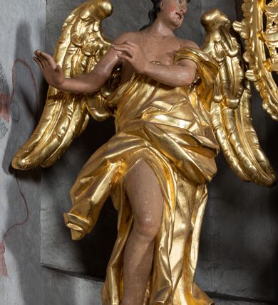 Zdjęcie nr 9: Nastawa ołtarzowa architektoniczna, jednoosiowa, jednokondygnacyjna ze zwieńczeniem z bramkami. Bramki z przejściami w formie stojącego prostokąta, zwieńczone fantazyjnym łukiem ujętym spływami wolutowymi, zakończonymi cokołami z figurami aniołów. Ołtarz kamienny w drewnianej obudowie z drewnianą mensą. Antepedium w formie leżącego prostokąta w profilowanej ramie, podzielone na pięć pól, w środkowym aplikowany monogram maryjny. Tabernakulum o wypukłej ścianie frontowej, ujęte w narożach ukośnie dostawionymi pilastrami o trzonach utworzonych z wolut. Drzwiczki w formie stojącego prostokąta zamkniętego łukiem wklęsło-wypukłym z uskokiem; w polu kielich z hostią w glorii. Tron wystawienia w formie zwężającego się ku górze cokołu o ściętych narożach, ujętych spływami wolutowymi. Z przodu owalny kartusz z monogramem IHS. Kondygnacja ustawiona na zdwojonym cokole, ujęta parą zwielokrotnionych pilastrów i parą kolumn wysuniętych do przodu o kapitelach kompozytowych, dźwigających imposty zwrócone do wewnątrz ołtarza oraz przerwany falisty przyczółek z siedzącą parą puttów. W polu środkowym profilowana rama w kształcie stojącego prostokąta z obrazem Matki Boskiej Częstochowskiej, na zasuwie obraz „Najświętsze Serce Jezusa”. Zwieńczenie w formie promienistej  glorii. W polu obłoki z otwartą księgą i uskrzydlonymi główkami anielskimi. Kondygnacja ujęta uszami utworzonymi z ażurowego ornamentu rocaille'owego z elementami wstęgi. Struktura polichromowana w kolorze beżowym, kolumny marmoryzowane w kolorze różowo-czerwonym, detale i ornamentyka złocone oraz srebrzone.