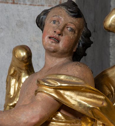 Zdjęcie nr 15: Nastawa ołtarzowa architektoniczna, jednoosiowa, jednokondygnacyjna ze zwieńczeniem z bramkami. Bramki z przejściami w formie stojącego prostokąta, zwieńczone fantazyjnym łukiem ujętym spływami wolutowymi, zakończonymi cokołami z figurami aniołów. Ołtarz kamienny w drewnianej obudowie z drewnianą mensą. Antepedium w formie leżącego prostokąta w profilowanej ramie, podzielone na pięć pól, w środkowym aplikowany monogram maryjny. Tabernakulum o wypukłej ścianie frontowej, ujęte w narożach ukośnie dostawionymi pilastrami o trzonach utworzonych z wolut. Drzwiczki w formie stojącego prostokąta zamkniętego łukiem wklęsło-wypukłym z uskokiem; w polu kielich z hostią w glorii. Tron wystawienia w formie zwężającego się ku górze cokołu o ściętych narożach, ujętych spływami wolutowymi. Z przodu owalny kartusz z monogramem IHS. Kondygnacja ustawiona na zdwojonym cokole, ujęta parą zwielokrotnionych pilastrów i parą kolumn wysuniętych do przodu o kapitelach kompozytowych, dźwigających imposty zwrócone do wewnątrz ołtarza oraz przerwany falisty przyczółek z siedzącą parą puttów. W polu środkowym profilowana rama w kształcie stojącego prostokąta z obrazem Matki Boskiej Częstochowskiej, na zasuwie obraz „Najświętsze Serce Jezusa”. Zwieńczenie w formie promienistej  glorii. W polu obłoki z otwartą księgą i uskrzydlonymi główkami anielskimi. Kondygnacja ujęta uszami utworzonymi z ażurowego ornamentu rocaille&#039;owego z elementami wstęgi. Struktura polichromowana w kolorze beżowym, kolumny marmoryzowane w kolorze różowo-czerwonym, detale i ornamentyka złocone oraz srebrzone.