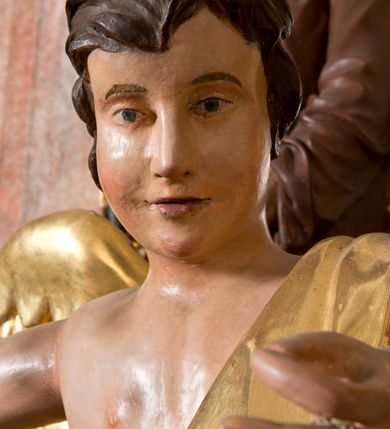 Zdjęcie nr 5: Rzeźby wolnostojące, ścięte z tyłu, drążone; ustawione na zdwojonych, niskich cokołach, stojących na czterech płaskich nóżkach. Figury ustawione w kontrapoście o ożywionych pozach z rękami uniesionymi do góry. Twarze młodzieńcze o spokojnych, podobnych rysach; włosy średniej długości, falowane, zasłaniające uszy. Figury ubrane w złote szaty, mocno drapowane, odsłaniające jedno ramię. Polichromia ciała naturalistyczna, szaty i skrzydła złocone. 