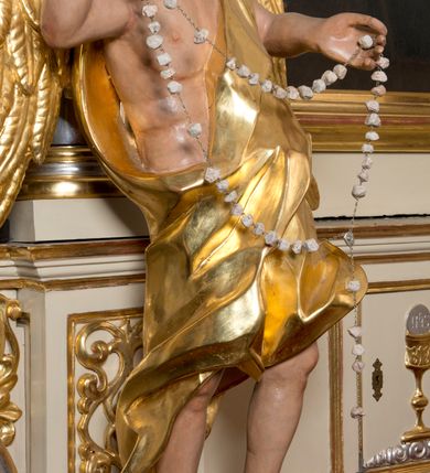 Zdjęcie nr 4: Rzeźby wolnostojące, ścięte z tyłu, drążone; ustawione na zdwojonych, niskich cokołach, stojących na czterech płaskich nóżkach. Figury ustawione w kontrapoście o ożywionych pozach z rękami uniesionymi do góry. Twarze młodzieńcze o spokojnych, podobnych rysach; włosy średniej długości, falowane, zasłaniające uszy. Figury ubrane w złote szaty, mocno drapowane, odsłaniające jedno ramię. Polichromia ciała naturalistyczna, szaty i skrzydła złocone. 