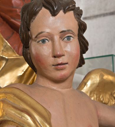 Zdjęcie nr 8: Rzeźby wolnostojące, ścięte z tyłu, drążone; ustawione na zdwojonych, niskich cokołach, stojących na czterech płaskich nóżkach. Figury ustawione w kontrapoście o ożywionych pozach z rękami uniesionymi do góry. Twarze młodzieńcze o spokojnych, podobnych rysach; włosy średniej długości, falowane, zasłaniające uszy. Figury ubrane w złote szaty, mocno drapowane, odsłaniające jedno ramię. Polichromia ciała naturalistyczna, szaty i skrzydła złocone. 