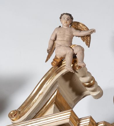 Zdjęcie nr 30: Ołtarz architektoniczny, jednokondygnacyjny, jednoosiowy ze zwieńczeniem. Ołtarz prostopadłościenny, z drewnianą mensą, z antepedium ujętym po bokach parą konsoli w formie wolut. Pole antepedium w postaci prostokątnej płyciny z płaskorzeźbionym motywem gorejącego serca pośrodku, ujętego promienistą glorią. Na mensie tabernakulum w formie prostopadłościennej szafki o wypukłej, przedniej  ściance ujętej dwoma parami osadzonych na niewielkich cokołach kolumienek wspierających niepełne, wyłamujące się ponad nimi belkowanie. Drzwiczki w kształcie stojącego prostokąta zamkniętego półkolistym łukiem nadwieszonym, zdobione motywem płaskorzeźbionego kielicha eucharystycznego. Struktura zdobiona motywami rozet i wici roślinnej. Retabulum osadzone na niewysokim, zryzalitowanym po bokach cokole. Część środkową nastawy ujmuje para ustawionych skośnie  filarów wspierających wyłamujące się ponad nimi belkowanie. Zamknięte półkoliście zwieńczenie ujmuje para spływów wolutowych oraz flankuje przerwany, wolutowy przyczółek. Pola wolutowych konsoli zdobi para liści akantu, cokół retabulum para stylizowanych słoneczników i S-kształtnych wici. Zewnętrzne pola trzonów filarów zdobią w górnych partiach ukwiecone gałązki, wewnętrzne motyw podwieszeń skomponowanych z zamkniętej korony, krzyżujących się rogów obfitości i krzyża z kotwicą, oraz kokard, u dołu para gałązek. Boki pola środkowego z motywem wici winnego grona, u góry w narożach para ulistnionych rozet. Fryz zdobiony rozetami, pośrodku kartusz w monogramem imienia Jezus ujętym parą gałązek laurowych. Retabulum flankowane parą ażurowych uszaków rocaille’owych. W dolnej partii zwieńczenia uskrzydlona główka anielska, szczyt w formie konchy ujętej po bokach parą rocaille’i. Na przerwanym przyczółku para figur aniołków. Pole części środkowej w kształcie stojącego prostokąta zamkniętego półkolistym łukiem nadwieszonym z uskokami, ujęte profilowaną, złoconą ramą, w środku wizerunek Najświętszego Serca Jezusa. Po bokach, na tle filarów para figur, po lewej św. Szczepan, po prawej św. Wawrzyniec. W zwieńczeniu obraz w kształcie trapezu o wklęsłych ramionach, podstawie i dolnych narożach, zamknięty półkolistym łukiem nadwieszonym, ujęty profilowaną, złoconą ramą, z wizerunkiem św. Katarzyny Aleksandryjskiej. 
Struktura w kolorze kremowym, detal architektoniczny i ornamentyka złocone.    
