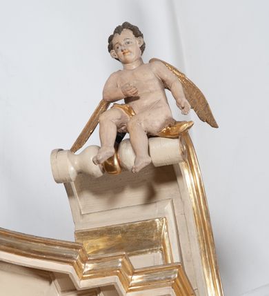 Zdjęcie nr 3: Ołtarz architektoniczny, jednokondygnacyjny, jednoosiowy ze zwieńczeniem. Ołtarz prostopadłościenny, z drewnianą mensą, z antepedium ujętym po bokach parą konsoli w formie wolut. Pole antepedium w postaci prostokątnej płyciny z płaskorzeźbionym motywem gorejącego serca pośrodku, ujętego promienistą glorią. Na mensie tabernakulum w formie prostopadłościennej szafki o wypukłej, przedniej  ściance ujętej dwoma parami osadzonych na niewielkich cokołach kolumienek wspierających niepełne, wyłamujące się ponad nimi belkowanie. Drzwiczki w kształcie stojącego prostokąta zamkniętego półkolistym łukiem nadwieszonym, zdobione motywem płaskorzeźbionego kielicha eucharystycznego. Struktura zdobiona motywami rozet i wici roślinnej. Retabulum osadzone na niewysokim, zryzalitowanym po bokach cokole. Część środkową nastawy ujmuje para ustawionych skośnie  filarów wspierających wyłamujące się ponad nimi belkowanie. Zamknięte półkoliście zwieńczenie ujmuje para spływów wolutowych oraz flankuje przerwany, wolutowy przyczółek. Pola wolutowych konsoli zdobi para liści akantu, cokół retabulum para stylizowanych słoneczników i S-kształtnych wici. Zewnętrzne pola trzonów filarów zdobią w górnych partiach ukwiecone gałązki, wewnętrzne motyw podwieszeń skomponowanych z zamkniętej korony, krzyżujących się rogów obfitości i krzyża z kotwicą, oraz kokard, u dołu para gałązek. Boki pola środkowego z motywem wici winnego grona, u góry w narożach para ulistnionych rozet. Fryz zdobiony rozetami, pośrodku kartusz w monogramem imienia Jezus ujętym parą gałązek laurowych. Retabulum flankowane parą ażurowych uszaków rocaille’owych. W dolnej partii zwieńczenia uskrzydlona główka anielska, szczyt w formie konchy ujętej po bokach parą rocaille’i. Na przerwanym przyczółku para figur aniołków. Pole części środkowej w kształcie stojącego prostokąta zamkniętego półkolistym łukiem nadwieszonym z uskokami, ujęte profilowaną, złoconą ramą, w środku wizerunek Najświętszego Serca Jezusa. Po bokach, na tle filarów para figur, po lewej św. Szczepan, po prawej św. Wawrzyniec. W zwieńczeniu obraz w kształcie trapezu o wklęsłych ramionach, podstawie i dolnych narożach, zamknięty półkolistym łukiem nadwieszonym, ujęty profilowaną, złoconą ramą, z wizerunkiem św. Katarzyny Aleksandryjskiej. 
Struktura w kolorze kremowym, detal architektoniczny i ornamentyka złocone.    
