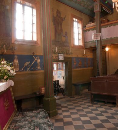 Zdjęcie nr 1: Ściany kościoła dekorują przedstawienia świętych: św. Stanisław w stroju pontyfikalnym z pastorałem, wskrzeszający Piotrowina. Poniżej na banderoli napis „BŁOGOSŁAWIENI KTÓRZY ŁAKNĄ / I PRAGNĄ SPRAWIEDLIWOŚCI”; św. Jadwiga w koronie i płaszczu podszytym gronostajem, trzymająca skrzyneczkę z klejnotami oraz krzyż z herbami Polski i Litwy. Na banderoli napis „BŁOGOSŁAWIENI / POKÓJ CZYNIĄCY”; św. Jan Kanty błogosławiący dziewczynę z dzbanem podpisany „BŁOGOSŁAWIENI / MIŁOSIERNI”; św. w habicie, z krzyżem w ręce i w asyście dwóch aniołów - jednego z palmą męczeństwa, drugiego z płonącą pochodnią, pod nimi napis „BŁOGOSŁAWIENI KTÓRZY / CIERPIĄ PRZEŚLADOWANIA DLA SPRAWIEDLIWOŚCI”; Chrystus z sercem gorejącym. Po jego prawej stronie klęczący mężczyzna, po lewej dwie owieczki nad strumieniem. Scena podpisana: „KTÓRZY PRACUJECIE I / OBCIĄŻENI JESTEŚCIE / A JA WAS OCHŁODZĘ”; archanioł Gabriel z lilią powyżej napisu  „ZDROWAŚ MARIO”; archanioł Michał z trybularzem, ponad napisem „KTÓŻ JAK BÓG!”; św. Franciszek na tle przyrody. Jest ubrany w habit franciszkański, na głowie ma kaptur. Przy prawej nodze świętego wilk, w jeziorze ryby, na niebie ptaki. Na banderoli napis „BŁOGOSŁAWIENI UBODZY DUCHEM / ALBOWIEM TAKOWYCH JEST / KRÓLESTWO NIEBIESKIE”; św. Izydor Oracz ukazany w towarzystwie anioła orającego na polu na tle dzwonnicy. Poniżej napis „BŁOGOSŁAWIENI CISI / ALBOWIEM ONI / POSIĄDĄ ZIEMIĘ”. Poniżej postaci świętych fryz z przedstawieniem 14 stacji drogi krzyżowej na błękitnym tle. Na stropie nawy i prezbiterium, na błękitnym tle, wśród kwiatowego ornamentu na środku ukazany Chrystus Ukrzyżowany ponad kielichem, gołębica Ducha Świętego i koronowana Maria. Po ich obu stronach stoją święci mężowie i niewiasty z atrybutami. W nawie w kolejności do środka: św. Wojciech (?), św. Jacek z figurą Matki Boskiej i monstrancją, klęczący św. Kazimierz w stroju książęcym z lilią, św. Agnieszka z barankiem i św. Karolina Kózkówna z różańcem, klęcząca św. Rozalia z różami, św. Klara z cyborium, św. Weronika z chustą z wizerunkiem Chrystusa, klęcząca św. Cecylia z lirą, św. Józef z lilią, św. Paweł z mieczem, klęczący św. Jan Chrzciciel z krzyżem. W prezbiterium przedstawiono 12 apostołów, niektórzy z atrybutmi, które ich jednoznacznie identyfilują, np. św. Andrzej z krzyżem w kształcie litery X, inni z księgami lub zwojami.  