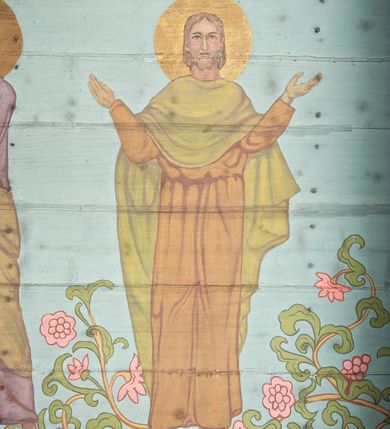 Zdjęcie nr 27: Ściany kościoła dekorują przedstawienia świętych: św. Stanisław w stroju pontyfikalnym z pastorałem, wskrzeszający Piotrowina. Poniżej na banderoli napis „BŁOGOSŁAWIENI KTÓRZY ŁAKNĄ / I PRAGNĄ SPRAWIEDLIWOŚCI”; św. Jadwiga w koronie i płaszczu podszytym gronostajem, trzymająca skrzyneczkę z klejnotami oraz krzyż z herbami Polski i Litwy. Na banderoli napis „BŁOGOSŁAWIENI / POKÓJ CZYNIĄCY”; św. Jan Kanty błogosławiący dziewczynę z dzbanem podpisany „BŁOGOSŁAWIENI / MIŁOSIERNI”; św. w habicie, z krzyżem w ręce i w asyście dwóch aniołów - jednego z palmą męczeństwa, drugiego z płonącą pochodnią, pod nimi napis „BŁOGOSŁAWIENI KTÓRZY / CIERPIĄ PRZEŚLADOWANIA DLA SPRAWIEDLIWOŚCI”; Chrystus z sercem gorejącym. Po jego prawej stronie klęczący mężczyzna, po lewej dwie owieczki nad strumieniem. Scena podpisana: „KTÓRZY PRACUJECIE I / OBCIĄŻENI JESTEŚCIE / A JA WAS OCHŁODZĘ”; archanioł Gabriel z lilią powyżej napisu  „ZDROWAŚ MARIO”; archanioł Michał z trybularzem, ponad napisem „KTÓŻ JAK BÓG!”; św. Franciszek na tle przyrody. Jest ubrany w habit franciszkański, na głowie ma kaptur. Przy prawej nodze świętego wilk, w jeziorze ryby, na niebie ptaki. Na banderoli napis „BŁOGOSŁAWIENI UBODZY DUCHEM / ALBOWIEM TAKOWYCH JEST / KRÓLESTWO NIEBIESKIE”; św. Izydor Oracz ukazany w towarzystwie anioła orającego na polu na tle dzwonnicy. Poniżej napis „BŁOGOSŁAWIENI CISI / ALBOWIEM ONI / POSIĄDĄ ZIEMIĘ”. Poniżej postaci świętych fryz z przedstawieniem 14 stacji drogi krzyżowej na błękitnym tle. Na stropie nawy i prezbiterium, na błękitnym tle, wśród kwiatowego ornamentu na środku ukazany Chrystus Ukrzyżowany ponad kielichem, gołębica Ducha Świętego i koronowana Maria. Po ich obu stronach stoją święci mężowie i niewiasty z atrybutami. W nawie w kolejności do środka: św. Wojciech (?), św. Jacek z figurą Matki Boskiej i monstrancją, klęczący św. Kazimierz w stroju książęcym z lilią, św. Agnieszka z barankiem i św. Karolina Kózkówna z różańcem, klęcząca św. Rozalia z różami, św. Klara z cyborium, św. Weronika z chustą z wizerunkiem Chrystusa, klęcząca św. Cecylia z lirą, św. Józef z lilią, św. Paweł z mieczem, klęczący św. Jan Chrzciciel z krzyżem. W prezbiterium przedstawiono 12 apostołów, niektórzy z atrybutmi, które ich jednoznacznie identyfilują, np. św. Andrzej z krzyżem w kształcie litery X, inni z księgami lub zwojami.  