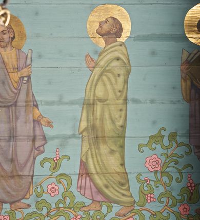 Zdjęcie nr 26: Ściany kościoła dekorują przedstawienia świętych: św. Stanisław w stroju pontyfikalnym z pastorałem, wskrzeszający Piotrowina. Poniżej na banderoli napis „BŁOGOSŁAWIENI KTÓRZY ŁAKNĄ / I PRAGNĄ SPRAWIEDLIWOŚCI”; św. Jadwiga w koronie i płaszczu podszytym gronostajem, trzymająca skrzyneczkę z klejnotami oraz krzyż z herbami Polski i Litwy. Na banderoli napis „BŁOGOSŁAWIENI / POKÓJ CZYNIĄCY”; św. Jan Kanty błogosławiący dziewczynę z dzbanem podpisany „BŁOGOSŁAWIENI / MIŁOSIERNI”; św. w habicie, z krzyżem w ręce i w asyście dwóch aniołów - jednego z palmą męczeństwa, drugiego z płonącą pochodnią, pod nimi napis „BŁOGOSŁAWIENI KTÓRZY / CIERPIĄ PRZEŚLADOWANIA DLA SPRAWIEDLIWOŚCI”; Chrystus z sercem gorejącym. Po jego prawej stronie klęczący mężczyzna, po lewej dwie owieczki nad strumieniem. Scena podpisana: „KTÓRZY PRACUJECIE I / OBCIĄŻENI JESTEŚCIE / A JA WAS OCHŁODZĘ”; archanioł Gabriel z lilią powyżej napisu  „ZDROWAŚ MARIO”; archanioł Michał z trybularzem, ponad napisem „KTÓŻ JAK BÓG!”; św. Franciszek na tle przyrody. Jest ubrany w habit franciszkański, na głowie ma kaptur. Przy prawej nodze świętego wilk, w jeziorze ryby, na niebie ptaki. Na banderoli napis „BŁOGOSŁAWIENI UBODZY DUCHEM / ALBOWIEM TAKOWYCH JEST / KRÓLESTWO NIEBIESKIE”; św. Izydor Oracz ukazany w towarzystwie anioła orającego na polu na tle dzwonnicy. Poniżej napis „BŁOGOSŁAWIENI CISI / ALBOWIEM ONI / POSIĄDĄ ZIEMIĘ”. Poniżej postaci świętych fryz z przedstawieniem 14 stacji drogi krzyżowej na błękitnym tle. Na stropie nawy i prezbiterium, na błękitnym tle, wśród kwiatowego ornamentu na środku ukazany Chrystus Ukrzyżowany ponad kielichem, gołębica Ducha Świętego i koronowana Maria. Po ich obu stronach stoją święci mężowie i niewiasty z atrybutami. W nawie w kolejności do środka: św. Wojciech (?), św. Jacek z figurą Matki Boskiej i monstrancją, klęczący św. Kazimierz w stroju książęcym z lilią, św. Agnieszka z barankiem i św. Karolina Kózkówna z różańcem, klęcząca św. Rozalia z różami, św. Klara z cyborium, św. Weronika z chustą z wizerunkiem Chrystusa, klęcząca św. Cecylia z lirą, św. Józef z lilią, św. Paweł z mieczem, klęczący św. Jan Chrzciciel z krzyżem. W prezbiterium przedstawiono 12 apostołów, niektórzy z atrybutmi, które ich jednoznacznie identyfilują, np. św. Andrzej z krzyżem w kształcie litery X, inni z księgami lub zwojami.  