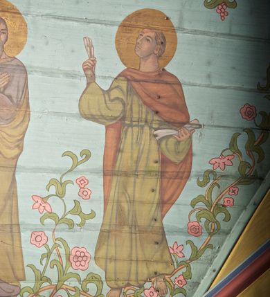 Zdjęcie nr 30: Ściany kościoła dekorują przedstawienia świętych: św. Stanisław w stroju pontyfikalnym z pastorałem, wskrzeszający Piotrowina. Poniżej na banderoli napis „BŁOGOSŁAWIENI KTÓRZY ŁAKNĄ / I PRAGNĄ SPRAWIEDLIWOŚCI”; św. Jadwiga w koronie i płaszczu podszytym gronostajem, trzymająca skrzyneczkę z klejnotami oraz krzyż z herbami Polski i Litwy. Na banderoli napis „BŁOGOSŁAWIENI / POKÓJ CZYNIĄCY”; św. Jan Kanty błogosławiący dziewczynę z dzbanem podpisany „BŁOGOSŁAWIENI / MIŁOSIERNI”; św. w habicie, z krzyżem w ręce i w asyście dwóch aniołów - jednego z palmą męczeństwa, drugiego z płonącą pochodnią, pod nimi napis „BŁOGOSŁAWIENI KTÓRZY / CIERPIĄ PRZEŚLADOWANIA DLA SPRAWIEDLIWOŚCI”; Chrystus z sercem gorejącym. Po jego prawej stronie klęczący mężczyzna, po lewej dwie owieczki nad strumieniem. Scena podpisana: „KTÓRZY PRACUJECIE I / OBCIĄŻENI JESTEŚCIE / A JA WAS OCHŁODZĘ”; archanioł Gabriel z lilią powyżej napisu  „ZDROWAŚ MARIO”; archanioł Michał z trybularzem, ponad napisem „KTÓŻ JAK BÓG!”; św. Franciszek na tle przyrody. Jest ubrany w habit franciszkański, na głowie ma kaptur. Przy prawej nodze świętego wilk, w jeziorze ryby, na niebie ptaki. Na banderoli napis „BŁOGOSŁAWIENI UBODZY DUCHEM / ALBOWIEM TAKOWYCH JEST / KRÓLESTWO NIEBIESKIE”; św. Izydor Oracz ukazany w towarzystwie anioła orającego na polu na tle dzwonnicy. Poniżej napis „BŁOGOSŁAWIENI CISI / ALBOWIEM ONI / POSIĄDĄ ZIEMIĘ”. Poniżej postaci świętych fryz z przedstawieniem 14 stacji drogi krzyżowej na błękitnym tle. Na stropie nawy i prezbiterium, na błękitnym tle, wśród kwiatowego ornamentu na środku ukazany Chrystus Ukrzyżowany ponad kielichem, gołębica Ducha Świętego i koronowana Maria. Po ich obu stronach stoją święci mężowie i niewiasty z atrybutami. W nawie w kolejności do środka: św. Wojciech (?), św. Jacek z figurą Matki Boskiej i monstrancją, klęczący św. Kazimierz w stroju książęcym z lilią, św. Agnieszka z barankiem i św. Karolina Kózkówna z różańcem, klęcząca św. Rozalia z różami, św. Klara z cyborium, św. Weronika z chustą z wizerunkiem Chrystusa, klęcząca św. Cecylia z lirą, św. Józef z lilią, św. Paweł z mieczem, klęczący św. Jan Chrzciciel z krzyżem. W prezbiterium przedstawiono 12 apostołów, niektórzy z atrybutmi, które ich jednoznacznie identyfilują, np. św. Andrzej z krzyżem w kształcie litery X, inni z księgami lub zwojami.  