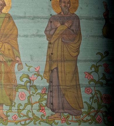 Zdjęcie nr 33: Ściany kościoła dekorują przedstawienia świętych: św. Stanisław w stroju pontyfikalnym z pastorałem, wskrzeszający Piotrowina. Poniżej na banderoli napis „BŁOGOSŁAWIENI KTÓRZY ŁAKNĄ / I PRAGNĄ SPRAWIEDLIWOŚCI”; św. Jadwiga w koronie i płaszczu podszytym gronostajem, trzymająca skrzyneczkę z klejnotami oraz krzyż z herbami Polski i Litwy. Na banderoli napis „BŁOGOSŁAWIENI / POKÓJ CZYNIĄCY”; św. Jan Kanty błogosławiący dziewczynę z dzbanem podpisany „BŁOGOSŁAWIENI / MIŁOSIERNI”; św. w habicie, z krzyżem w ręce i w asyście dwóch aniołów - jednego z palmą męczeństwa, drugiego z płonącą pochodnią, pod nimi napis „BŁOGOSŁAWIENI KTÓRZY / CIERPIĄ PRZEŚLADOWANIA DLA SPRAWIEDLIWOŚCI”; Chrystus z sercem gorejącym. Po jego prawej stronie klęczący mężczyzna, po lewej dwie owieczki nad strumieniem. Scena podpisana: „KTÓRZY PRACUJECIE I / OBCIĄŻENI JESTEŚCIE / A JA WAS OCHŁODZĘ”; archanioł Gabriel z lilią powyżej napisu  „ZDROWAŚ MARIO”; archanioł Michał z trybularzem, ponad napisem „KTÓŻ JAK BÓG!”; św. Franciszek na tle przyrody. Jest ubrany w habit franciszkański, na głowie ma kaptur. Przy prawej nodze świętego wilk, w jeziorze ryby, na niebie ptaki. Na banderoli napis „BŁOGOSŁAWIENI UBODZY DUCHEM / ALBOWIEM TAKOWYCH JEST / KRÓLESTWO NIEBIESKIE”; św. Izydor Oracz ukazany w towarzystwie anioła orającego na polu na tle dzwonnicy. Poniżej napis „BŁOGOSŁAWIENI CISI / ALBOWIEM ONI / POSIĄDĄ ZIEMIĘ”. Poniżej postaci świętych fryz z przedstawieniem 14 stacji drogi krzyżowej na błękitnym tle. Na stropie nawy i prezbiterium, na błękitnym tle, wśród kwiatowego ornamentu na środku ukazany Chrystus Ukrzyżowany ponad kielichem, gołębica Ducha Świętego i koronowana Maria. Po ich obu stronach stoją święci mężowie i niewiasty z atrybutami. W nawie w kolejności do środka: św. Wojciech (?), św. Jacek z figurą Matki Boskiej i monstrancją, klęczący św. Kazimierz w stroju książęcym z lilią, św. Agnieszka z barankiem i św. Karolina Kózkówna z różańcem, klęcząca św. Rozalia z różami, św. Klara z cyborium, św. Weronika z chustą z wizerunkiem Chrystusa, klęcząca św. Cecylia z lirą, św. Józef z lilią, św. Paweł z mieczem, klęczący św. Jan Chrzciciel z krzyżem. W prezbiterium przedstawiono 12 apostołów, niektórzy z atrybutmi, które ich jednoznacznie identyfilują, np. św. Andrzej z krzyżem w kształcie litery X, inni z księgami lub zwojami.  