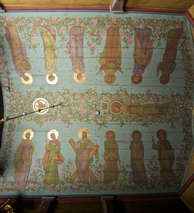 Zdjęcie nr 11: Ściany kościoła dekorują przedstawienia świętych: św. Stanisław w stroju pontyfikalnym z pastorałem, wskrzeszający Piotrowina. Poniżej na banderoli napis „BŁOGOSŁAWIENI KTÓRZY ŁAKNĄ / I PRAGNĄ SPRAWIEDLIWOŚCI”; św. Jadwiga w koronie i płaszczu podszytym gronostajem, trzymająca skrzyneczkę z klejnotami oraz krzyż z herbami Polski i Litwy. Na banderoli napis „BŁOGOSŁAWIENI / POKÓJ CZYNIĄCY”; św. Jan Kanty błogosławiący dziewczynę z dzbanem podpisany „BŁOGOSŁAWIENI / MIŁOSIERNI”; św. w habicie, z krzyżem w ręce i w asyście dwóch aniołów - jednego z palmą męczeństwa, drugiego z płonącą pochodnią, pod nimi napis „BŁOGOSŁAWIENI KTÓRZY / CIERPIĄ PRZEŚLADOWANIA DLA SPRAWIEDLIWOŚCI”; Chrystus z sercem gorejącym. Po jego prawej stronie klęczący mężczyzna, po lewej dwie owieczki nad strumieniem. Scena podpisana: „KTÓRZY PRACUJECIE I / OBCIĄŻENI JESTEŚCIE / A JA WAS OCHŁODZĘ”; archanioł Gabriel z lilią powyżej napisu  „ZDROWAŚ MARIO”; archanioł Michał z trybularzem, ponad napisem „KTÓŻ JAK BÓG!”; św. Franciszek na tle przyrody. Jest ubrany w habit franciszkański, na głowie ma kaptur. Przy prawej nodze świętego wilk, w jeziorze ryby, na niebie ptaki. Na banderoli napis „BŁOGOSŁAWIENI UBODZY DUCHEM / ALBOWIEM TAKOWYCH JEST / KRÓLESTWO NIEBIESKIE”; św. Izydor Oracz ukazany w towarzystwie anioła orającego na polu na tle dzwonnicy. Poniżej napis „BŁOGOSŁAWIENI CISI / ALBOWIEM ONI / POSIĄDĄ ZIEMIĘ”. Poniżej postaci świętych fryz z przedstawieniem 14 stacji drogi krzyżowej na błękitnym tle. Na stropie nawy i prezbiterium, na błękitnym tle, wśród kwiatowego ornamentu na środku ukazany Chrystus Ukrzyżowany ponad kielichem, gołębica Ducha Świętego i koronowana Maria. Po ich obu stronach stoją święci mężowie i niewiasty z atrybutami. W nawie w kolejności do środka: św. Wojciech (?), św. Jacek z figurą Matki Boskiej i monstrancją, klęczący św. Kazimierz w stroju książęcym z lilią, św. Agnieszka z barankiem i św. Karolina Kózkówna z różańcem, klęcząca św. Rozalia z różami, św. Klara z cyborium, św. Weronika z chustą z wizerunkiem Chrystusa, klęcząca św. Cecylia z lirą, św. Józef z lilią, św. Paweł z mieczem, klęczący św. Jan Chrzciciel z krzyżem. W prezbiterium przedstawiono 12 apostołów, niektórzy z atrybutmi, które ich jednoznacznie identyfilują, np. św. Andrzej z krzyżem w kształcie litery X, inni z księgami lub zwojami.  