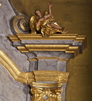 Zdjęcie nr 4: Ołtarz architektoniczny, jednoosiowy, jednokondygnacyjny. Mensa prostopadłościenna z antepedium haftowanym bogatą dekoracją kwiatową, z centralnie umieszczonym kielichem w otoczeniu winnej latorośli. Na nim tabernakulum w formie zbliżonej do prostopadłościennej skrzynki o wypukłej ściance frontowej na tle ścianki z tronem wystawienia ustawionej na cokole i ujętej spływami wolutowymi. Drzwiczki tabernakulum dekorowane krzyżem z glorią między literami „Α” i „Ω”. Tron wystawienia złocony, dekorowany kwiatem między stylizowanymi liśćmi i ujęty od góry muszlą palmetową. Tron ujmują lizeny przedzielone i zwieńczone gzymsem ustawionym skośnie i zakończonym od wewnętrznej strony wolutami. Gzyms nad tronem wystawienia wyniesiony, w formie łuku nadwieszonego. Na jego zewnętrznych częściach posadowiono figurki klęczących i modlących się aniołków. Nastawa ujęta parą zdwojonych pilastrów na cokołach, o głowicach korynckich, z impostami z dekoracją w formie festonów z rocaille’em i liśćmi. Uszy w formie spływów wolutowych z dekoracją liściastą. W centrum pole obrazowe z wnęką o profilowanej ramie w kształcie stojącego prostokąta ujętego w spływy wolutowe i festony, zwieńczone wydatnym kartuszem dekorowanym rocaille’em, z monogramem maryjnym. W nim ukazana Matka Boska Anielska przesłaniana obrazem „Wszyscy Święci” wzorowanym na obrazie Rafaela. Retabulum przedzielone gzymsem wyniesionym w łuk ponad polem centralnym. Zwieńczenie w formie zbliżonej do prostokąta, rozszerzające się ku dołowi, ujęte w esowate pilastry przechodzące w woluty, zamknięte łukiem odcinkowym zakończonym wolutami. Całość wieńczy krzyż z rozetą na skrzyżowaniu ramion. W zwieńczeniu wklęsło-wypukłe pole obrazowe z płaskorzeźbionym popiersiem Boga Ojca na tle nieba. Na impostach leżące figury aniołów. Struktura polichromowana, marmoryzowana w odcieniu jasnoszarym, profile, ornamenty i dekoracje złocone i srebrzone. 