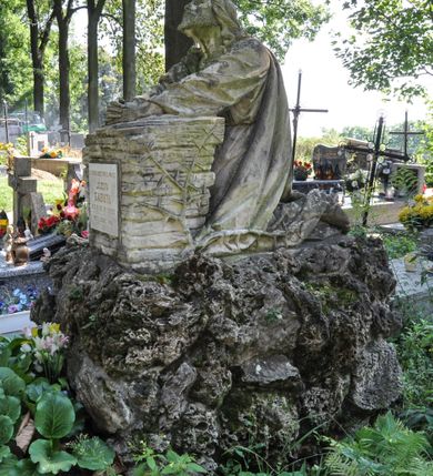 Zdjęcie nr 1: Nagrobek kamienny, wolnostojący z przedstawieniem modlitwy Chrystusa w Ogrójcu. Rzeźba posadowiona na bloku imitującym skały, na którym umieszczono Zbawiciela klęczącego przed pulpitem wybudowanym z kamieni. Chrystus złożone do modlitwy ręce wyciąga przed siebie i opiera na pulpicie, głowę ma uniesioną, spogląda w niebo. Ma podłużną twarz, na której maluje się wyraz rozpaczy, krótką brodę i długie włosy opadające puklami na ramiona i plecy. Jest ubrany w długą, przepasaną suknię i płaszcz. Na przedniej stronie pulpitu tablica z kutą, złoconą inskrypcją „ZA SPOKÓJ DUSZY ŚWIĘTEJ PAMIĘCI / JÓZEFA / GABUTA / UR(ODZONEGO) 2. VII 1910 ZM(ARŁEGO) 11. IV 1933. / PROSI O ZDROWAŚ MARIA”.