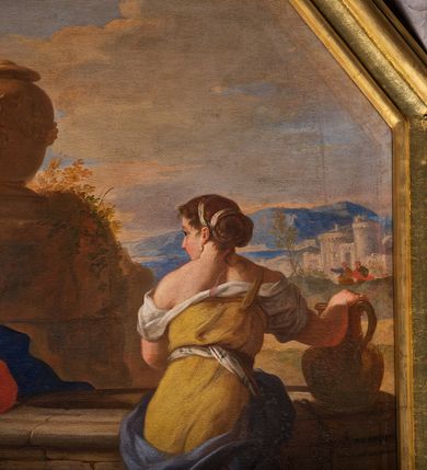 Zdjęcie nr 3: Obraz w ośmiobocznej, profilowanej, złoconej ramie. Na tle górzystego pejzażu z widocznymi w oddali, po prawej stronie zabudowaniami miejskimi oraz wzniesieniem z ustawionym na nim wazonem po lewej stronie przedstawiona scena spotkania Chrystusa z Samarytanką przy studni. Po lewej stronie siedzi Chrystus, zwrócony w trzech czwartych w lewo, prawą uniesioną powyżej głowy ręką wskazuje na niebo, lewą wspartą o studnię przyciska do piersi. Twarz pociągła z prostym nosem, półprzymkniętymi oczami okolona ciemnobrązowym zarostem i długimi, falującymi włosami opadającymi na ramiona. Chrystus ubrany w czerwoną szatę przewiązaną w pasie oraz ciemnoniebieski płaszcz przerzucony z przodu przez kolana i lewe ramię. Po prawej stronie ukazana Samarytanka wchodząca po stopniach studni, przedstawiona od tyłu z głową zwróconą w stronę Chrystusa, prawą rękę opiera na dzbanie stojącym na brzegu studni, lewą unosząca na wysokość piersi. Kobieta ubrana w żółtą suknię, odsłaniającą ramiona, przewiązaną w pasie oraz niebieski płaszcz okrywający biodra. Kolorystyka ciepła, z przewagą brązów i żółcieni, z dominantą w postaci czerwonego płaszcza Chrystusa. Obraz malowany walorowo.