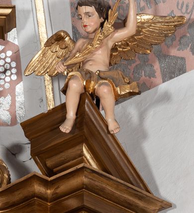 Zdjęcie nr 4: Ołtarz przyścienny, architektoniczny, jednoosiowy, jednokondygnacyjny ze zwieńczeniem. Mensa drewniana w kształcie prostopadłościennej skrzyni z narożami lekko wysuniętymi przed jej lico. Antependium drewniane z umieszczoną w centrum prostokątną płyciną z płaskorzeźbioną sceną Ostatniej Wieczerzy według Leonarda da Vinci. Po bokach po dwie mniejsze płyciny w kształcie prostokąta stojącego wypełnione płaskorzeźbioną, złoconą dekoracją z winnym gronem, kłosami, kwiatami oraz muszlą palmetową. 
Tabernakulum w kształcie prostopadłościennej, obitej metalową blachą skrzynki, dwudrzwiowe. Na drzwiczkach odlewana dekoracja z kłosów i winnych gron, powyżej gorejące serce. Tabernakulum ujęte drewnianym tronem wystawienia w formie ażurowej kolumnady na planie półkola. Zwieńczone ażurowymi wolutami tworzącymi formę baldachimu. U szczytu korona zamknięta, u jej podstawy Baranek Apokaliptyczny. 
Retabulum ustawione na wysokim cokole z bokami zwróconymi pod kątem 45 stopni, zwieńczonym wydatnym profilowanym gzymsem. Na ścianach cokołów uskrzydlone główki aniołów z podwieszonym ornamentem o motywach cęgowych i roślinnych. Kondygnacja flankowana jest parą kolumn podtrzymujących niepełne belkowanie. Kolumny o kapitelach kompozytowych, marmoryzowanych trzonach, z nałożoną do połowy dekoracją w formie ornamentalnej wici roślinnej złożonej z motywów akantu, rocaille&#039;u, palmety i ornamentu cęgowego. Na gzymsie fragmenty przerwanego trójkątnego przyczółka, na których siedzą pełnoplastyczne figury aniołków. Pole główne ołtarza o lekko zaoblonych narożach, w jego centrum złocona, profilowana rama w otoku z cierniowej korony, o kształcie prostokąta stojącego zakończonego półkoliście. Pośrodku obraz Matki Boskiej Częstochowskiej oraz obraz Ukrzyżowanie na zasuwie, ponad którym umieszczona jest płaskorzeźba Boga Ojca. Powyżej, na osi ołtarza złocona korona z krzyżykiem. 
Zwieńczenie ujęte jest kolumnami analogicznymi jak w kondygnacji dźwigającymi niepełne, przełamane na osi podpór belkowanie o linii wklęsło-wypukłej. W polu promienista gloria z gołębicą Ducha Świętego na tle obłoków. Po bokach zwieńczenia znajdują się spływy wolutowe dekorowane kwiatami. U szczytu krzyż wyrastający z palmety. Ołtarz malowany na kolor brązowy, złocenia w partiach profili elementów architektonicznych i ornamentów złocone, detale srebrzone.