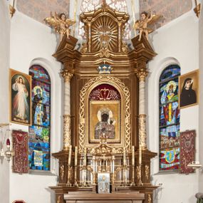 Zdjęcie nr 1: Ołtarz przyścienny, architektoniczny, jednoosiowy, jednokondygnacyjny ze zwieńczeniem. Mensa drewniana w kształcie prostopadłościennej skrzyni z narożami lekko wysuniętymi przed jej lico. Antependium drewniane z umieszczoną w centrum prostokątną płyciną z płaskorzeźbioną sceną Ostatniej Wieczerzy według Leonarda da Vinci. Po bokach po dwie mniejsze płyciny w kształcie prostokąta stojącego wypełnione płaskorzeźbioną, złoconą dekoracją z winnym gronem, kłosami, kwiatami oraz muszlą palmetową. 
Tabernakulum w kształcie prostopadłościennej, obitej metalową blachą skrzynki, dwudrzwiowe. Na drzwiczkach odlewana dekoracja z kłosów i winnych gron, powyżej gorejące serce. Tabernakulum ujęte drewnianym tronem wystawienia w formie ażurowej kolumnady na planie półkola. Zwieńczone ażurowymi wolutami tworzącymi formę baldachimu. U szczytu korona zamknięta, u jej podstawy Baranek Apokaliptyczny. 
Retabulum ustawione na wysokim cokole z bokami zwróconymi pod kątem 45 stopni, zwieńczonym wydatnym profilowanym gzymsem. Na ścianach cokołów uskrzydlone główki aniołów z podwieszonym ornamentem o motywach cęgowych i roślinnych. Kondygnacja flankowana jest parą kolumn podtrzymujących niepełne belkowanie. Kolumny o kapitelach kompozytowych, marmoryzowanych trzonach, z nałożoną do połowy dekoracją w formie ornamentalnej wici roślinnej złożonej z motywów akantu, rocaille'u, palmety i ornamentu cęgowego. Na gzymsie fragmenty przerwanego trójkątnego przyczółka, na których siedzą pełnoplastyczne figury aniołków. Pole główne ołtarza o lekko zaoblonych narożach, w jego centrum złocona, profilowana rama w otoku z cierniowej korony, o kształcie prostokąta stojącego zakończonego półkoliście. Pośrodku obraz Matki Boskiej Częstochowskiej oraz obraz Ukrzyżowanie na zasuwie, ponad którym umieszczona jest płaskorzeźba Boga Ojca. Powyżej, na osi ołtarza złocona korona z krzyżykiem. 
Zwieńczenie ujęte jest kolumnami analogicznymi jak w kondygnacji dźwigającymi niepełne, przełamane na osi podpór belkowanie o linii wklęsło-wypukłej. W polu promienista gloria z gołębicą Ducha Świętego na tle obłoków. Po bokach zwieńczenia znajdują się spływy wolutowe dekorowane kwiatami. U szczytu krzyż wyrastający z palmety. Ołtarz malowany na kolor brązowy, złocenia w partiach profili elementów architektonicznych i ornamentów złocone, detale srebrzone.