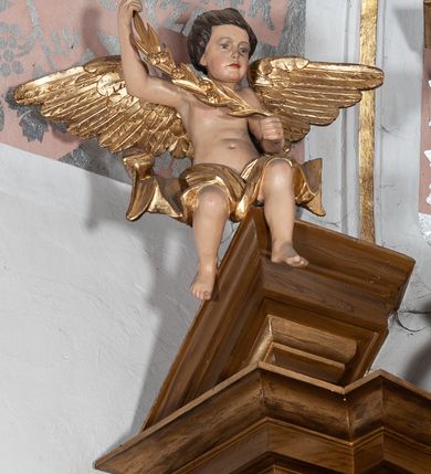 Zdjęcie nr 3: Ołtarz przyścienny, architektoniczny, jednoosiowy, jednokondygnacyjny ze zwieńczeniem. Mensa drewniana w kształcie prostopadłościennej skrzyni z narożami lekko wysuniętymi przed jej lico. Antependium drewniane z umieszczoną w centrum prostokątną płyciną z płaskorzeźbioną sceną Ostatniej Wieczerzy według Leonarda da Vinci. Po bokach po dwie mniejsze płyciny w kształcie prostokąta stojącego wypełnione płaskorzeźbioną, złoconą dekoracją z winnym gronem, kłosami, kwiatami oraz muszlą palmetową. 
Tabernakulum w kształcie prostopadłościennej, obitej metalową blachą skrzynki, dwudrzwiowe. Na drzwiczkach odlewana dekoracja z kłosów i winnych gron, powyżej gorejące serce. Tabernakulum ujęte drewnianym tronem wystawienia w formie ażurowej kolumnady na planie półkola. Zwieńczone ażurowymi wolutami tworzącymi formę baldachimu. U szczytu korona zamknięta, u jej podstawy Baranek Apokaliptyczny. 
Retabulum ustawione na wysokim cokole z bokami zwróconymi pod kątem 45 stopni, zwieńczonym wydatnym profilowanym gzymsem. Na ścianach cokołów uskrzydlone główki aniołów z podwieszonym ornamentem o motywach cęgowych i roślinnych. Kondygnacja flankowana jest parą kolumn podtrzymujących niepełne belkowanie. Kolumny o kapitelach kompozytowych, marmoryzowanych trzonach, z nałożoną do połowy dekoracją w formie ornamentalnej wici roślinnej złożonej z motywów akantu, rocaille'u, palmety i ornamentu cęgowego. Na gzymsie fragmenty przerwanego trójkątnego przyczółka, na których siedzą pełnoplastyczne figury aniołków. Pole główne ołtarza o lekko zaoblonych narożach, w jego centrum złocona, profilowana rama w otoku z cierniowej korony, o kształcie prostokąta stojącego zakończonego półkoliście. Pośrodku obraz Matki Boskiej Częstochowskiej oraz obraz Ukrzyżowanie na zasuwie, ponad którym umieszczona jest płaskorzeźba Boga Ojca. Powyżej, na osi ołtarza złocona korona z krzyżykiem. 
Zwieńczenie ujęte jest kolumnami analogicznymi jak w kondygnacji dźwigającymi niepełne, przełamane na osi podpór belkowanie o linii wklęsło-wypukłej. W polu promienista gloria z gołębicą Ducha Świętego na tle obłoków. Po bokach zwieńczenia znajdują się spływy wolutowe dekorowane kwiatami. U szczytu krzyż wyrastający z palmety. Ołtarz malowany na kolor brązowy, złocenia w partiach profili elementów architektonicznych i ornamentów złocone, detale srebrzone.