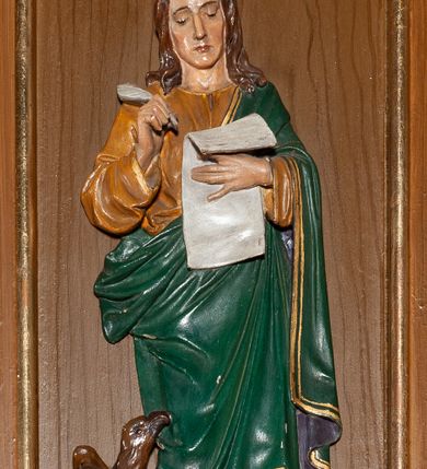 Zdjęcie nr 4: Ambona przyścienna, wisząca. Kosz ośmioboczny z silnie profilowaną podstawą, zakończony u dołu szyszką. Ścianki kosza zdobione pięcioma płycinami w formie stojących prostokątów, zamkniętych łukiem odcinkowym, z opaską malowaną na złoto. W każdej z czterech płycin płaskorzeźbione i polichromowane przedstawienie jednego z ewangelistów: Marka, Mateusza, Łukasza i Jana. Każda z postaci ukazana całopostaciowo, frontalnie, ze zwojem w lewej ręce, prawą czyniąca gest błogosławieństwa. U stóp ewangelistów przedstawiono odpowiadające im atrybuty: św. Marka – lew, św. Jana – orzeł, św. Mateusza – człowiek, św. Łukasza – wół. Balustrada ambony z belkowaniem, zdobionym motywem rautów we fryzie i kostkowaniem pod gzymsem. Ambona dostępna przez drewniane schody, od wschodu. Balustrada schodów zdobiona czterema romboidalnymi płycinami o brzegach malowanych na złoto. Struktura malowana w kolorze naturalnego drewna, detale i ornamentyka złocone.