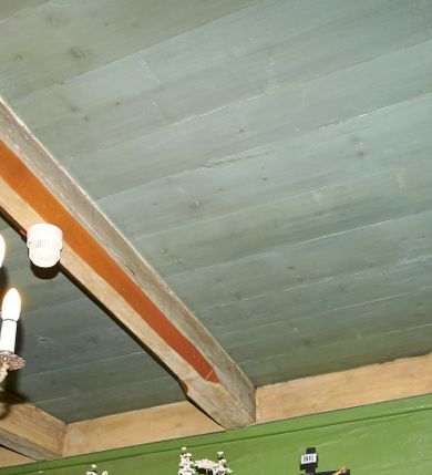 Zdjęcie nr 49: Polichromia ścian kościoła odpowiada podziałom architektonicznym wnętrza wydzielonym przez pilastry. Malowany zielony cokół w jednej czwartej wysokości ścian wyodrębniony jest pasem ornamentu geometrycznego, w nawie w jego polu znajdują się żółte prostokąty z dekoracją geometryczną, w prezbiterium malowana jasnozielona tkanina z dwoma pasami ornamentu roślinnego, medalionami z monogramami Marii i koronami oraz z motywem lilii heraldycznych i rozet. Trzony pilastrów wnętrza bladożółte z malowanymi płycinami dekorowanymi kampanulami, głowice zdobione malowanym kimationem. Na osi pilastrów, w partii fryzu, na tle niebieskich prostokątów uskrzydlone główki anielskie, pomiędzy nimi fryz wypełniony różowo-pomarańczowymi malowanymi płycinami w błękitnym obramieniu o fantazyjnym wykroju, dekorowanymi kampanulami. Belkowanie zamknięte malowanym pasem ornamentu geometrycznego. W polach pomiędzy pilastrami malowane płyciny o fantazyjnym kształcie zbliżonym do prostokąta, ujęte ramą zakończoną kartuszem, ich pola wypełnione są dekoracją geometryczną składającą się z krzyży równoramiennych w glorii i rozet wykonanych techniką patronową. Otwory okienne ujęte są malowanymi, imitującymi profilowanie obramieniami, otwory drzwiowe iluzjonistycznymi portalami z uszakami: portal w nawie zwieńczony jest kartuszem, a portal w prezbiterium zwieńczony jest szczytem zamkniętym fragmentem gzymsu w formie łuku segmentowego nadwieszonego podtrzymywanym przez spływy wolutowe. Pod chórem muzycznym malowane tablice pamiątkowe ujęte ramą, na ścianie północnej z napisem: „Ecclam hanc sub titulo Assumptionis B.V. Mariae a strenuo / milite Wierzbięta in Branice et Ruszcza Haerede pimo in / Wola juxta fines villae Stryjów a D. 1386 fundatam decimis / ex praedio Branice a colonis Stryjów, Wola, cuius sors est Grabie / Szczurów Zymbrzeg et ibidem taberna cum duobus pratis ac lacubus / Orzek et Piotrek ditatam, proper alluviem Vistulae  curatus suus / in hunc locum, qui erat pratum Gruczyn, ecclae dotale transtulit, / Hac tandem post annos 356 collapsa, quam vides, A.R.D. Jacobus Cichoński, parochus Grabiensis a.D. 1742 in loco desolatae  novam erexit. / Consecravit Illmus ac Rmus Michaël Kunicki, Sufraganeus Eppus. / Cracoviensis, Abbas Clarae Tumbae a D. 1749. / Restauravit A.R.D. Josephus Raźny, parochus Grabiensis a.D. 1907. / e colectis parochianorum.”; na ścianie południowej z napisem: „Ku Pamięci! / Dzieci Moje Najmilsze - Ja Prastara Świątynia / Polska dziękuję Wam za serdeczną troskę / o mnie. Oto dzięki Waszym ofiarom Drodzy / Rodzice i Twoim wysiłkom Kochana Młodzieży / w r. 1959 odnowiło się moje oblicze - rozjaśniały /  moje ołtarze, a w r. 1960 zabrzmiał mój nowy / organ na większą chwałę Bożą. Ja Was za to / rodzę na nowo do życia łaski. Ja Was błogosławię / na życie rodzinne. Ja Was prowadzę ku Bogu. Ja / Was także żegnam poraz ostatni, gdy przechodzicie / z tego padołu płaczu do wieczności, aby / Was znowu powitać kiedyś w niebie.”. Na ścianie zachodniej, pod chórem, nad środkowym otworem przejściowym pozostałości dawnego iluzjonistycznego portalu z kartuszem herbowym. Na stropie prezbiterium wydzielone pole o kształcie powtarzającym plan prezbiterium, wewnątrz pole w formie kwadratu o wklęsłych narożach z wpisanym polem o fantazyjnym zarysie zbliżonym do owalu ze sceną Wniebowzięcia Najświętszej Marii Panny. W narożach owalne pola z czterema istotami apokaliptycznymi. Prosta belka tęczowa w kolorze zielonym, o profilowaniach w kolorze niebieskim i różowym, z napisem: „JEZU ZMIŁUJ SIĘ NAD NAMI”. Na stropie nawy prostokątne pole wydzielone grubym bladoróżowym obramieniem z płycinami o nieregularnym kształcie wypełnionymi kratką regencyjną i rozetami alternowanymi medalionami z rozetami, naroża dekorowane są wstęgą regencyjną i akantem. Wewnątrz pole o fantazyjnym wykroju zbliżonym do owalu ze sceną Koronacji Najświętszej Marii Panny, flankowane przez dwie malowane błękitne płyciny o nieregularnym kształcie wypełnione rozetkami. W narożach, w ozdobnych kartuszach herby Pogoni Litewskiej i Orła Białego.
