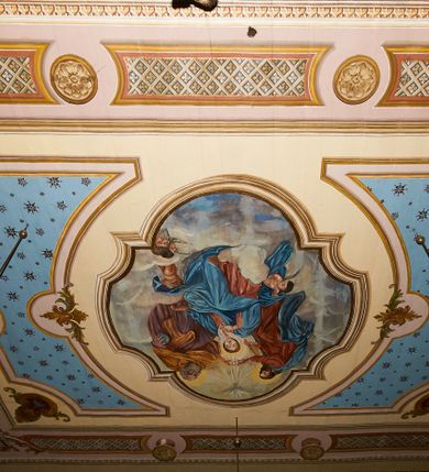 Zdjęcie nr 19: Polichromia ścian kościoła odpowiada podziałom architektonicznym wnętrza wydzielonym przez pilastry. Malowany zielony cokół w jednej czwartej wysokości ścian wyodrębniony jest pasem ornamentu geometrycznego, w nawie w jego polu znajdują się żółte prostokąty z dekoracją geometryczną, w prezbiterium malowana jasnozielona tkanina z dwoma pasami ornamentu roślinnego, medalionami z monogramami Marii i koronami oraz z motywem lilii heraldycznych i rozet. Trzony pilastrów wnętrza bladożółte z malowanymi płycinami dekorowanymi kampanulami, głowice zdobione malowanym kimationem. Na osi pilastrów, w partii fryzu, na tle niebieskich prostokątów uskrzydlone główki anielskie, pomiędzy nimi fryz wypełniony różowo-pomarańczowymi malowanymi płycinami w błękitnym obramieniu o fantazyjnym wykroju, dekorowanymi kampanulami. Belkowanie zamknięte malowanym pasem ornamentu geometrycznego. W polach pomiędzy pilastrami malowane płyciny o fantazyjnym kształcie zbliżonym do prostokąta, ujęte ramą zakończoną kartuszem, ich pola wypełnione są dekoracją geometryczną składającą się z krzyży równoramiennych w glorii i rozet wykonanych techniką patronową. Otwory okienne ujęte są malowanymi, imitującymi profilowanie obramieniami, otwory drzwiowe iluzjonistycznymi portalami z uszakami: portal w nawie zwieńczony jest kartuszem, a portal w prezbiterium zwieńczony jest szczytem zamkniętym fragmentem gzymsu w formie łuku segmentowego nadwieszonego podtrzymywanym przez spływy wolutowe. Pod chórem muzycznym malowane tablice pamiątkowe ujęte ramą, na ścianie północnej z napisem: „Ecclam hanc sub titulo Assumptionis B.V. Mariae a strenuo / milite Wierzbięta in Branice et Ruszcza Haerede pimo in / Wola juxta fines villae Stryjów a D. 1386 fundatam decimis / ex praedio Branice a colonis Stryjów, Wola, cuius sors est Grabie / Szczurów Zymbrzeg et ibidem taberna cum duobus pratis ac lacubus / Orzek et Piotrek ditatam, proper alluviem Vistulae  curatus suus / in hunc locum, qui erat pratum Gruczyn, ecclae dotale transtulit, / Hac tandem post annos 356 collapsa, quam vides, A.R.D. Jacobus Cichoński, parochus Grabiensis a.D. 1742 in loco desolatae  novam erexit. / Consecravit Illmus ac Rmus Michaël Kunicki, Sufraganeus Eppus. / Cracoviensis, Abbas Clarae Tumbae a D. 1749. / Restauravit A.R.D. Josephus Raźny, parochus Grabiensis a.D. 1907. / e colectis parochianorum.”; na ścianie południowej z napisem: „Ku Pamięci! / Dzieci Moje Najmilsze - Ja Prastara Świątynia / Polska dziękuję Wam za serdeczną troskę / o mnie. Oto dzięki Waszym ofiarom Drodzy / Rodzice i Twoim wysiłkom Kochana Młodzieży / w r. 1959 odnowiło się moje oblicze - rozjaśniały /  moje ołtarze, a w r. 1960 zabrzmiał mój nowy / organ na większą chwałę Bożą. Ja Was za to / rodzę na nowo do życia łaski. Ja Was błogosławię / na życie rodzinne. Ja Was prowadzę ku Bogu. Ja / Was także żegnam poraz ostatni, gdy przechodzicie / z tego padołu płaczu do wieczności, aby / Was znowu powitać kiedyś w niebie.”. Na ścianie zachodniej, pod chórem, nad środkowym otworem przejściowym pozostałości dawnego iluzjonistycznego portalu z kartuszem herbowym. Na stropie prezbiterium wydzielone pole o kształcie powtarzającym plan prezbiterium, wewnątrz pole w formie kwadratu o wklęsłych narożach z wpisanym polem o fantazyjnym zarysie zbliżonym do owalu ze sceną Wniebowzięcia Najświętszej Marii Panny. W narożach owalne pola z czterema istotami apokaliptycznymi. Prosta belka tęczowa w kolorze zielonym, o profilowaniach w kolorze niebieskim i różowym, z napisem: „JEZU ZMIŁUJ SIĘ NAD NAMI”. Na stropie nawy prostokątne pole wydzielone grubym bladoróżowym obramieniem z płycinami o nieregularnym kształcie wypełnionymi kratką regencyjną i rozetami alternowanymi medalionami z rozetami, naroża dekorowane są wstęgą regencyjną i akantem. Wewnątrz pole o fantazyjnym wykroju zbliżonym do owalu ze sceną Koronacji Najświętszej Marii Panny, flankowane przez dwie malowane błękitne płyciny o nieregularnym kształcie wypełnione rozetkami. W narożach, w ozdobnych kartuszach herby Pogoni Litewskiej i Orła Białego.
