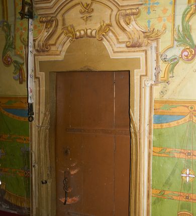 Zdjęcie nr 27: Polichromia ścian kościoła odpowiada podziałom architektonicznym wnętrza wydzielonym przez pilastry. Malowany zielony cokół w jednej czwartej wysokości ścian wyodrębniony jest pasem ornamentu geometrycznego, w nawie w jego polu znajdują się żółte prostokąty z dekoracją geometryczną, w prezbiterium malowana jasnozielona tkanina z dwoma pasami ornamentu roślinnego, medalionami z monogramami Marii i koronami oraz z motywem lilii heraldycznych i rozet. Trzony pilastrów wnętrza bladożółte z malowanymi płycinami dekorowanymi kampanulami, głowice zdobione malowanym kimationem. Na osi pilastrów, w partii fryzu, na tle niebieskich prostokątów uskrzydlone główki anielskie, pomiędzy nimi fryz wypełniony różowo-pomarańczowymi malowanymi płycinami w błękitnym obramieniu o fantazyjnym wykroju, dekorowanymi kampanulami. Belkowanie zamknięte malowanym pasem ornamentu geometrycznego. W polach pomiędzy pilastrami malowane płyciny o fantazyjnym kształcie zbliżonym do prostokąta, ujęte ramą zakończoną kartuszem, ich pola wypełnione są dekoracją geometryczną składającą się z krzyży równoramiennych w glorii i rozet wykonanych techniką patronową. Otwory okienne ujęte są malowanymi, imitującymi profilowanie obramieniami, otwory drzwiowe iluzjonistycznymi portalami z uszakami: portal w nawie zwieńczony jest kartuszem, a portal w prezbiterium zwieńczony jest szczytem zamkniętym fragmentem gzymsu w formie łuku segmentowego nadwieszonego podtrzymywanym przez spływy wolutowe. Pod chórem muzycznym malowane tablice pamiątkowe ujęte ramą, na ścianie północnej z napisem: „Ecclam hanc sub titulo Assumptionis B.V. Mariae a strenuo / milite Wierzbięta in Branice et Ruszcza Haerede pimo in / Wola juxta fines villae Stryjów a D. 1386 fundatam decimis / ex praedio Branice a colonis Stryjów, Wola, cuius sors est Grabie / Szczurów Zymbrzeg et ibidem taberna cum duobus pratis ac lacubus / Orzek et Piotrek ditatam, proper alluviem Vistulae  curatus suus / in hunc locum, qui erat pratum Gruczyn, ecclae dotale transtulit, / Hac tandem post annos 356 collapsa, quam vides, A.R.D. Jacobus Cichoński, parochus Grabiensis a.D. 1742 in loco desolatae  novam erexit. / Consecravit Illmus ac Rmus Michaël Kunicki, Sufraganeus Eppus. / Cracoviensis, Abbas Clarae Tumbae a D. 1749. / Restauravit A.R.D. Josephus Raźny, parochus Grabiensis a.D. 1907. / e colectis parochianorum.”; na ścianie południowej z napisem: „Ku Pamięci! / Dzieci Moje Najmilsze - Ja Prastara Świątynia / Polska dziękuję Wam za serdeczną troskę / o mnie. Oto dzięki Waszym ofiarom Drodzy / Rodzice i Twoim wysiłkom Kochana Młodzieży / w r. 1959 odnowiło się moje oblicze - rozjaśniały /  moje ołtarze, a w r. 1960 zabrzmiał mój nowy / organ na większą chwałę Bożą. Ja Was za to / rodzę na nowo do życia łaski. Ja Was błogosławię / na życie rodzinne. Ja Was prowadzę ku Bogu. Ja / Was także żegnam poraz ostatni, gdy przechodzicie / z tego padołu płaczu do wieczności, aby / Was znowu powitać kiedyś w niebie.”. Na ścianie zachodniej, pod chórem, nad środkowym otworem przejściowym pozostałości dawnego iluzjonistycznego portalu z kartuszem herbowym. Na stropie prezbiterium wydzielone pole o kształcie powtarzającym plan prezbiterium, wewnątrz pole w formie kwadratu o wklęsłych narożach z wpisanym polem o fantazyjnym zarysie zbliżonym do owalu ze sceną Wniebowzięcia Najświętszej Marii Panny. W narożach owalne pola z czterema istotami apokaliptycznymi. Prosta belka tęczowa w kolorze zielonym, o profilowaniach w kolorze niebieskim i różowym, z napisem: „JEZU ZMIŁUJ SIĘ NAD NAMI”. Na stropie nawy prostokątne pole wydzielone grubym bladoróżowym obramieniem z płycinami o nieregularnym kształcie wypełnionymi kratką regencyjną i rozetami alternowanymi medalionami z rozetami, naroża dekorowane są wstęgą regencyjną i akantem. Wewnątrz pole o fantazyjnym wykroju zbliżonym do owalu ze sceną Koronacji Najświętszej Marii Panny, flankowane przez dwie malowane błękitne płyciny o nieregularnym kształcie wypełnione rozetkami. W narożach, w ozdobnych kartuszach herby Pogoni Litewskiej i Orła Białego.
