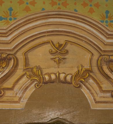 Zdjęcie nr 26: Polichromia ścian kościoła odpowiada podziałom architektonicznym wnętrza wydzielonym przez pilastry. Malowany zielony cokół w jednej czwartej wysokości ścian wyodrębniony jest pasem ornamentu geometrycznego, w nawie w jego polu znajdują się żółte prostokąty z dekoracją geometryczną, w prezbiterium malowana jasnozielona tkanina z dwoma pasami ornamentu roślinnego, medalionami z monogramami Marii i koronami oraz z motywem lilii heraldycznych i rozet. Trzony pilastrów wnętrza bladożółte z malowanymi płycinami dekorowanymi kampanulami, głowice zdobione malowanym kimationem. Na osi pilastrów, w partii fryzu, na tle niebieskich prostokątów uskrzydlone główki anielskie, pomiędzy nimi fryz wypełniony różowo-pomarańczowymi malowanymi płycinami w błękitnym obramieniu o fantazyjnym wykroju, dekorowanymi kampanulami. Belkowanie zamknięte malowanym pasem ornamentu geometrycznego. W polach pomiędzy pilastrami malowane płyciny o fantazyjnym kształcie zbliżonym do prostokąta, ujęte ramą zakończoną kartuszem, ich pola wypełnione są dekoracją geometryczną składającą się z krzyży równoramiennych w glorii i rozet wykonanych techniką patronową. Otwory okienne ujęte są malowanymi, imitującymi profilowanie obramieniami, otwory drzwiowe iluzjonistycznymi portalami z uszakami: portal w nawie zwieńczony jest kartuszem, a portal w prezbiterium zwieńczony jest szczytem zamkniętym fragmentem gzymsu w formie łuku segmentowego nadwieszonego podtrzymywanym przez spływy wolutowe. Pod chórem muzycznym malowane tablice pamiątkowe ujęte ramą, na ścianie północnej z napisem: „Ecclam hanc sub titulo Assumptionis B.V. Mariae a strenuo / milite Wierzbięta in Branice et Ruszcza Haerede pimo in / Wola juxta fines villae Stryjów a D. 1386 fundatam decimis / ex praedio Branice a colonis Stryjów, Wola, cuius sors est Grabie / Szczurów Zymbrzeg et ibidem taberna cum duobus pratis ac lacubus / Orzek et Piotrek ditatam, proper alluviem Vistulae  curatus suus / in hunc locum, qui erat pratum Gruczyn, ecclae dotale transtulit, / Hac tandem post annos 356 collapsa, quam vides, A.R.D. Jacobus Cichoński, parochus Grabiensis a.D. 1742 in loco desolatae  novam erexit. / Consecravit Illmus ac Rmus Michaël Kunicki, Sufraganeus Eppus. / Cracoviensis, Abbas Clarae Tumbae a D. 1749. / Restauravit A.R.D. Josephus Raźny, parochus Grabiensis a.D. 1907. / e colectis parochianorum.”; na ścianie południowej z napisem: „Ku Pamięci! / Dzieci Moje Najmilsze - Ja Prastara Świątynia / Polska dziękuję Wam za serdeczną troskę / o mnie. Oto dzięki Waszym ofiarom Drodzy / Rodzice i Twoim wysiłkom Kochana Młodzieży / w r. 1959 odnowiło się moje oblicze - rozjaśniały /  moje ołtarze, a w r. 1960 zabrzmiał mój nowy / organ na większą chwałę Bożą. Ja Was za to / rodzę na nowo do życia łaski. Ja Was błogosławię / na życie rodzinne. Ja Was prowadzę ku Bogu. Ja / Was także żegnam poraz ostatni, gdy przechodzicie / z tego padołu płaczu do wieczności, aby / Was znowu powitać kiedyś w niebie.”. Na ścianie zachodniej, pod chórem, nad środkowym otworem przejściowym pozostałości dawnego iluzjonistycznego portalu z kartuszem herbowym. Na stropie prezbiterium wydzielone pole o kształcie powtarzającym plan prezbiterium, wewnątrz pole w formie kwadratu o wklęsłych narożach z wpisanym polem o fantazyjnym zarysie zbliżonym do owalu ze sceną Wniebowzięcia Najświętszej Marii Panny. W narożach owalne pola z czterema istotami apokaliptycznymi. Prosta belka tęczowa w kolorze zielonym, o profilowaniach w kolorze niebieskim i różowym, z napisem: „JEZU ZMIŁUJ SIĘ NAD NAMI”. Na stropie nawy prostokątne pole wydzielone grubym bladoróżowym obramieniem z płycinami o nieregularnym kształcie wypełnionymi kratką regencyjną i rozetami alternowanymi medalionami z rozetami, naroża dekorowane są wstęgą regencyjną i akantem. Wewnątrz pole o fantazyjnym wykroju zbliżonym do owalu ze sceną Koronacji Najświętszej Marii Panny, flankowane przez dwie malowane błękitne płyciny o nieregularnym kształcie wypełnione rozetkami. W narożach, w ozdobnych kartuszach herby Pogoni Litewskiej i Orła Białego.
