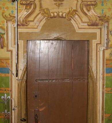 Zdjęcie nr 25: Polichromia ścian kościoła odpowiada podziałom architektonicznym wnętrza wydzielonym przez pilastry. Malowany zielony cokół w jednej czwartej wysokości ścian wyodrębniony jest pasem ornamentu geometrycznego, w nawie w jego polu znajdują się żółte prostokąty z dekoracją geometryczną, w prezbiterium malowana jasnozielona tkanina z dwoma pasami ornamentu roślinnego, medalionami z monogramami Marii i koronami oraz z motywem lilii heraldycznych i rozet. Trzony pilastrów wnętrza bladożółte z malowanymi płycinami dekorowanymi kampanulami, głowice zdobione malowanym kimationem. Na osi pilastrów, w partii fryzu, na tle niebieskich prostokątów uskrzydlone główki anielskie, pomiędzy nimi fryz wypełniony różowo-pomarańczowymi malowanymi płycinami w błękitnym obramieniu o fantazyjnym wykroju, dekorowanymi kampanulami. Belkowanie zamknięte malowanym pasem ornamentu geometrycznego. W polach pomiędzy pilastrami malowane płyciny o fantazyjnym kształcie zbliżonym do prostokąta, ujęte ramą zakończoną kartuszem, ich pola wypełnione są dekoracją geometryczną składającą się z krzyży równoramiennych w glorii i rozet wykonanych techniką patronową. Otwory okienne ujęte są malowanymi, imitującymi profilowanie obramieniami, otwory drzwiowe iluzjonistycznymi portalami z uszakami: portal w nawie zwieńczony jest kartuszem, a portal w prezbiterium zwieńczony jest szczytem zamkniętym fragmentem gzymsu w formie łuku segmentowego nadwieszonego podtrzymywanym przez spływy wolutowe. Pod chórem muzycznym malowane tablice pamiątkowe ujęte ramą, na ścianie północnej z napisem: „Ecclam hanc sub titulo Assumptionis B.V. Mariae a strenuo / milite Wierzbięta in Branice et Ruszcza Haerede pimo in / Wola juxta fines villae Stryjów a D. 1386 fundatam decimis / ex praedio Branice a colonis Stryjów, Wola, cuius sors est Grabie / Szczurów Zymbrzeg et ibidem taberna cum duobus pratis ac lacubus / Orzek et Piotrek ditatam, proper alluviem Vistulae  curatus suus / in hunc locum, qui erat pratum Gruczyn, ecclae dotale transtulit, / Hac tandem post annos 356 collapsa, quam vides, A.R.D. Jacobus Cichoński, parochus Grabiensis a.D. 1742 in loco desolatae  novam erexit. / Consecravit Illmus ac Rmus Michaël Kunicki, Sufraganeus Eppus. / Cracoviensis, Abbas Clarae Tumbae a D. 1749. / Restauravit A.R.D. Josephus Raźny, parochus Grabiensis a.D. 1907. / e colectis parochianorum.”; na ścianie południowej z napisem: „Ku Pamięci! / Dzieci Moje Najmilsze - Ja Prastara Świątynia / Polska dziękuję Wam za serdeczną troskę / o mnie. Oto dzięki Waszym ofiarom Drodzy / Rodzice i Twoim wysiłkom Kochana Młodzieży / w r. 1959 odnowiło się moje oblicze - rozjaśniały /  moje ołtarze, a w r. 1960 zabrzmiał mój nowy / organ na większą chwałę Bożą. Ja Was za to / rodzę na nowo do życia łaski. Ja Was błogosławię / na życie rodzinne. Ja Was prowadzę ku Bogu. Ja / Was także żegnam poraz ostatni, gdy przechodzicie / z tego padołu płaczu do wieczności, aby / Was znowu powitać kiedyś w niebie.”. Na ścianie zachodniej, pod chórem, nad środkowym otworem przejściowym pozostałości dawnego iluzjonistycznego portalu z kartuszem herbowym. Na stropie prezbiterium wydzielone pole o kształcie powtarzającym plan prezbiterium, wewnątrz pole w formie kwadratu o wklęsłych narożach z wpisanym polem o fantazyjnym zarysie zbliżonym do owalu ze sceną Wniebowzięcia Najświętszej Marii Panny. W narożach owalne pola z czterema istotami apokaliptycznymi. Prosta belka tęczowa w kolorze zielonym, o profilowaniach w kolorze niebieskim i różowym, z napisem: „JEZU ZMIŁUJ SIĘ NAD NAMI”. Na stropie nawy prostokątne pole wydzielone grubym bladoróżowym obramieniem z płycinami o nieregularnym kształcie wypełnionymi kratką regencyjną i rozetami alternowanymi medalionami z rozetami, naroża dekorowane są wstęgą regencyjną i akantem. Wewnątrz pole o fantazyjnym wykroju zbliżonym do owalu ze sceną Koronacji Najświętszej Marii Panny, flankowane przez dwie malowane błękitne płyciny o nieregularnym kształcie wypełnione rozetkami. W narożach, w ozdobnych kartuszach herby Pogoni Litewskiej i Orła Białego.
