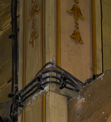 Zdjęcie nr 48: Polichromia ścian kościoła odpowiada podziałom architektonicznym wnętrza wydzielonym przez pilastry. Malowany zielony cokół w jednej czwartej wysokości ścian wyodrębniony jest pasem ornamentu geometrycznego, w nawie w jego polu znajdują się żółte prostokąty z dekoracją geometryczną, w prezbiterium malowana jasnozielona tkanina z dwoma pasami ornamentu roślinnego, medalionami z monogramami Marii i koronami oraz z motywem lilii heraldycznych i rozet. Trzony pilastrów wnętrza bladożółte z malowanymi płycinami dekorowanymi kampanulami, głowice zdobione malowanym kimationem. Na osi pilastrów, w partii fryzu, na tle niebieskich prostokątów uskrzydlone główki anielskie, pomiędzy nimi fryz wypełniony różowo-pomarańczowymi malowanymi płycinami w błękitnym obramieniu o fantazyjnym wykroju, dekorowanymi kampanulami. Belkowanie zamknięte malowanym pasem ornamentu geometrycznego. W polach pomiędzy pilastrami malowane płyciny o fantazyjnym kształcie zbliżonym do prostokąta, ujęte ramą zakończoną kartuszem, ich pola wypełnione są dekoracją geometryczną składającą się z krzyży równoramiennych w glorii i rozet wykonanych techniką patronową. Otwory okienne ujęte są malowanymi, imitującymi profilowanie obramieniami, otwory drzwiowe iluzjonistycznymi portalami z uszakami: portal w nawie zwieńczony jest kartuszem, a portal w prezbiterium zwieńczony jest szczytem zamkniętym fragmentem gzymsu w formie łuku segmentowego nadwieszonego podtrzymywanym przez spływy wolutowe. Pod chórem muzycznym malowane tablice pamiątkowe ujęte ramą, na ścianie północnej z napisem: „Ecclam hanc sub titulo Assumptionis B.V. Mariae a strenuo / milite Wierzbięta in Branice et Ruszcza Haerede pimo in / Wola juxta fines villae Stryjów a D. 1386 fundatam decimis / ex praedio Branice a colonis Stryjów, Wola, cuius sors est Grabie / Szczurów Zymbrzeg et ibidem taberna cum duobus pratis ac lacubus / Orzek et Piotrek ditatam, proper alluviem Vistulae  curatus suus / in hunc locum, qui erat pratum Gruczyn, ecclae dotale transtulit, / Hac tandem post annos 356 collapsa, quam vides, A.R.D. Jacobus Cichoński, parochus Grabiensis a.D. 1742 in loco desolatae  novam erexit. / Consecravit Illmus ac Rmus Michaël Kunicki, Sufraganeus Eppus. / Cracoviensis, Abbas Clarae Tumbae a D. 1749. / Restauravit A.R.D. Josephus Raźny, parochus Grabiensis a.D. 1907. / e colectis parochianorum.”; na ścianie południowej z napisem: „Ku Pamięci! / Dzieci Moje Najmilsze - Ja Prastara Świątynia / Polska dziękuję Wam za serdeczną troskę / o mnie. Oto dzięki Waszym ofiarom Drodzy / Rodzice i Twoim wysiłkom Kochana Młodzieży / w r. 1959 odnowiło się moje oblicze - rozjaśniały /  moje ołtarze, a w r. 1960 zabrzmiał mój nowy / organ na większą chwałę Bożą. Ja Was za to / rodzę na nowo do życia łaski. Ja Was błogosławię / na życie rodzinne. Ja Was prowadzę ku Bogu. Ja / Was także żegnam poraz ostatni, gdy przechodzicie / z tego padołu płaczu do wieczności, aby / Was znowu powitać kiedyś w niebie.”. Na ścianie zachodniej, pod chórem, nad środkowym otworem przejściowym pozostałości dawnego iluzjonistycznego portalu z kartuszem herbowym. Na stropie prezbiterium wydzielone pole o kształcie powtarzającym plan prezbiterium, wewnątrz pole w formie kwadratu o wklęsłych narożach z wpisanym polem o fantazyjnym zarysie zbliżonym do owalu ze sceną Wniebowzięcia Najświętszej Marii Panny. W narożach owalne pola z czterema istotami apokaliptycznymi. Prosta belka tęczowa w kolorze zielonym, o profilowaniach w kolorze niebieskim i różowym, z napisem: „JEZU ZMIŁUJ SIĘ NAD NAMI”. Na stropie nawy prostokątne pole wydzielone grubym bladoróżowym obramieniem z płycinami o nieregularnym kształcie wypełnionymi kratką regencyjną i rozetami alternowanymi medalionami z rozetami, naroża dekorowane są wstęgą regencyjną i akantem. Wewnątrz pole o fantazyjnym wykroju zbliżonym do owalu ze sceną Koronacji Najświętszej Marii Panny, flankowane przez dwie malowane błękitne płyciny o nieregularnym kształcie wypełnione rozetkami. W narożach, w ozdobnych kartuszach herby Pogoni Litewskiej i Orła Białego.
