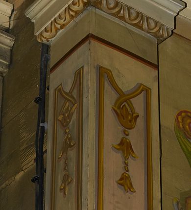 Zdjęcie nr 47: Polichromia ścian kościoła odpowiada podziałom architektonicznym wnętrza wydzielonym przez pilastry. Malowany zielony cokół w jednej czwartej wysokości ścian wyodrębniony jest pasem ornamentu geometrycznego, w nawie w jego polu znajdują się żółte prostokąty z dekoracją geometryczną, w prezbiterium malowana jasnozielona tkanina z dwoma pasami ornamentu roślinnego, medalionami z monogramami Marii i koronami oraz z motywem lilii heraldycznych i rozet. Trzony pilastrów wnętrza bladożółte z malowanymi płycinami dekorowanymi kampanulami, głowice zdobione malowanym kimationem. Na osi pilastrów, w partii fryzu, na tle niebieskich prostokątów uskrzydlone główki anielskie, pomiędzy nimi fryz wypełniony różowo-pomarańczowymi malowanymi płycinami w błękitnym obramieniu o fantazyjnym wykroju, dekorowanymi kampanulami. Belkowanie zamknięte malowanym pasem ornamentu geometrycznego. W polach pomiędzy pilastrami malowane płyciny o fantazyjnym kształcie zbliżonym do prostokąta, ujęte ramą zakończoną kartuszem, ich pola wypełnione są dekoracją geometryczną składającą się z krzyży równoramiennych w glorii i rozet wykonanych techniką patronową. Otwory okienne ujęte są malowanymi, imitującymi profilowanie obramieniami, otwory drzwiowe iluzjonistycznymi portalami z uszakami: portal w nawie zwieńczony jest kartuszem, a portal w prezbiterium zwieńczony jest szczytem zamkniętym fragmentem gzymsu w formie łuku segmentowego nadwieszonego podtrzymywanym przez spływy wolutowe. Pod chórem muzycznym malowane tablice pamiątkowe ujęte ramą, na ścianie północnej z napisem: „Ecclam hanc sub titulo Assumptionis B.V. Mariae a strenuo / milite Wierzbięta in Branice et Ruszcza Haerede pimo in / Wola juxta fines villae Stryjów a D. 1386 fundatam decimis / ex praedio Branice a colonis Stryjów, Wola, cuius sors est Grabie / Szczurów Zymbrzeg et ibidem taberna cum duobus pratis ac lacubus / Orzek et Piotrek ditatam, proper alluviem Vistulae  curatus suus / in hunc locum, qui erat pratum Gruczyn, ecclae dotale transtulit, / Hac tandem post annos 356 collapsa, quam vides, A.R.D. Jacobus Cichoński, parochus Grabiensis a.D. 1742 in loco desolatae  novam erexit. / Consecravit Illmus ac Rmus Michaël Kunicki, Sufraganeus Eppus. / Cracoviensis, Abbas Clarae Tumbae a D. 1749. / Restauravit A.R.D. Josephus Raźny, parochus Grabiensis a.D. 1907. / e colectis parochianorum.”; na ścianie południowej z napisem: „Ku Pamięci! / Dzieci Moje Najmilsze - Ja Prastara Świątynia / Polska dziękuję Wam za serdeczną troskę / o mnie. Oto dzięki Waszym ofiarom Drodzy / Rodzice i Twoim wysiłkom Kochana Młodzieży / w r. 1959 odnowiło się moje oblicze - rozjaśniały /  moje ołtarze, a w r. 1960 zabrzmiał mój nowy / organ na większą chwałę Bożą. Ja Was za to / rodzę na nowo do życia łaski. Ja Was błogosławię / na życie rodzinne. Ja Was prowadzę ku Bogu. Ja / Was także żegnam poraz ostatni, gdy przechodzicie / z tego padołu płaczu do wieczności, aby / Was znowu powitać kiedyś w niebie.”. Na ścianie zachodniej, pod chórem, nad środkowym otworem przejściowym pozostałości dawnego iluzjonistycznego portalu z kartuszem herbowym. Na stropie prezbiterium wydzielone pole o kształcie powtarzającym plan prezbiterium, wewnątrz pole w formie kwadratu o wklęsłych narożach z wpisanym polem o fantazyjnym zarysie zbliżonym do owalu ze sceną Wniebowzięcia Najświętszej Marii Panny. W narożach owalne pola z czterema istotami apokaliptycznymi. Prosta belka tęczowa w kolorze zielonym, o profilowaniach w kolorze niebieskim i różowym, z napisem: „JEZU ZMIŁUJ SIĘ NAD NAMI”. Na stropie nawy prostokątne pole wydzielone grubym bladoróżowym obramieniem z płycinami o nieregularnym kształcie wypełnionymi kratką regencyjną i rozetami alternowanymi medalionami z rozetami, naroża dekorowane są wstęgą regencyjną i akantem. Wewnątrz pole o fantazyjnym wykroju zbliżonym do owalu ze sceną Koronacji Najświętszej Marii Panny, flankowane przez dwie malowane błękitne płyciny o nieregularnym kształcie wypełnione rozetkami. W narożach, w ozdobnych kartuszach herby Pogoni Litewskiej i Orła Białego.
