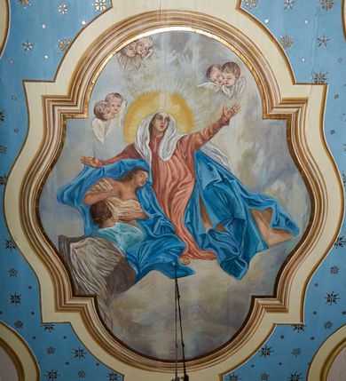 Zdjęcie nr 37: Polichromia ścian kościoła odpowiada podziałom architektonicznym wnętrza wydzielonym przez pilastry. Malowany zielony cokół w jednej czwartej wysokości ścian wyodrębniony jest pasem ornamentu geometrycznego, w nawie w jego polu znajdują się żółte prostokąty z dekoracją geometryczną, w prezbiterium malowana jasnozielona tkanina z dwoma pasami ornamentu roślinnego, medalionami z monogramami Marii i koronami oraz z motywem lilii heraldycznych i rozet. Trzony pilastrów wnętrza bladożółte z malowanymi płycinami dekorowanymi kampanulami, głowice zdobione malowanym kimationem. Na osi pilastrów, w partii fryzu, na tle niebieskich prostokątów uskrzydlone główki anielskie, pomiędzy nimi fryz wypełniony różowo-pomarańczowymi malowanymi płycinami w błękitnym obramieniu o fantazyjnym wykroju, dekorowanymi kampanulami. Belkowanie zamknięte malowanym pasem ornamentu geometrycznego. W polach pomiędzy pilastrami malowane płyciny o fantazyjnym kształcie zbliżonym do prostokąta, ujęte ramą zakończoną kartuszem, ich pola wypełnione są dekoracją geometryczną składającą się z krzyży równoramiennych w glorii i rozet wykonanych techniką patronową. Otwory okienne ujęte są malowanymi, imitującymi profilowanie obramieniami, otwory drzwiowe iluzjonistycznymi portalami z uszakami: portal w nawie zwieńczony jest kartuszem, a portal w prezbiterium zwieńczony jest szczytem zamkniętym fragmentem gzymsu w formie łuku segmentowego nadwieszonego podtrzymywanym przez spływy wolutowe. Pod chórem muzycznym malowane tablice pamiątkowe ujęte ramą, na ścianie północnej z napisem: „Ecclam hanc sub titulo Assumptionis B.V. Mariae a strenuo / milite Wierzbięta in Branice et Ruszcza Haerede pimo in / Wola juxta fines villae Stryjów a D. 1386 fundatam decimis / ex praedio Branice a colonis Stryjów, Wola, cuius sors est Grabie / Szczurów Zymbrzeg et ibidem taberna cum duobus pratis ac lacubus / Orzek et Piotrek ditatam, proper alluviem Vistulae  curatus suus / in hunc locum, qui erat pratum Gruczyn, ecclae dotale transtulit, / Hac tandem post annos 356 collapsa, quam vides, A.R.D. Jacobus Cichoński, parochus Grabiensis a.D. 1742 in loco desolatae  novam erexit. / Consecravit Illmus ac Rmus Michaël Kunicki, Sufraganeus Eppus. / Cracoviensis, Abbas Clarae Tumbae a D. 1749. / Restauravit A.R.D. Josephus Raźny, parochus Grabiensis a.D. 1907. / e colectis parochianorum.”; na ścianie południowej z napisem: „Ku Pamięci! / Dzieci Moje Najmilsze - Ja Prastara Świątynia / Polska dziękuję Wam za serdeczną troskę / o mnie. Oto dzięki Waszym ofiarom Drodzy / Rodzice i Twoim wysiłkom Kochana Młodzieży / w r. 1959 odnowiło się moje oblicze - rozjaśniały /  moje ołtarze, a w r. 1960 zabrzmiał mój nowy / organ na większą chwałę Bożą. Ja Was za to / rodzę na nowo do życia łaski. Ja Was błogosławię / na życie rodzinne. Ja Was prowadzę ku Bogu. Ja / Was także żegnam poraz ostatni, gdy przechodzicie / z tego padołu płaczu do wieczności, aby / Was znowu powitać kiedyś w niebie.”. Na ścianie zachodniej, pod chórem, nad środkowym otworem przejściowym pozostałości dawnego iluzjonistycznego portalu z kartuszem herbowym. Na stropie prezbiterium wydzielone pole o kształcie powtarzającym plan prezbiterium, wewnątrz pole w formie kwadratu o wklęsłych narożach z wpisanym polem o fantazyjnym zarysie zbliżonym do owalu ze sceną Wniebowzięcia Najświętszej Marii Panny. W narożach owalne pola z czterema istotami apokaliptycznymi. Prosta belka tęczowa w kolorze zielonym, o profilowaniach w kolorze niebieskim i różowym, z napisem: „JEZU ZMIŁUJ SIĘ NAD NAMI”. Na stropie nawy prostokątne pole wydzielone grubym bladoróżowym obramieniem z płycinami o nieregularnym kształcie wypełnionymi kratką regencyjną i rozetami alternowanymi medalionami z rozetami, naroża dekorowane są wstęgą regencyjną i akantem. Wewnątrz pole o fantazyjnym wykroju zbliżonym do owalu ze sceną Koronacji Najświętszej Marii Panny, flankowane przez dwie malowane błękitne płyciny o nieregularnym kształcie wypełnione rozetkami. W narożach, w ozdobnych kartuszach herby Pogoni Litewskiej i Orła Białego.
