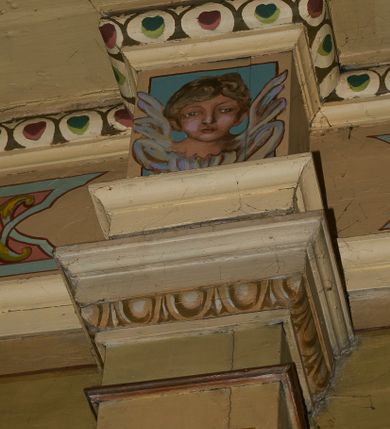 Zdjęcie nr 43: Polichromia ścian kościoła odpowiada podziałom architektonicznym wnętrza wydzielonym przez pilastry. Malowany zielony cokół w jednej czwartej wysokości ścian wyodrębniony jest pasem ornamentu geometrycznego, w nawie w jego polu znajdują się żółte prostokąty z dekoracją geometryczną, w prezbiterium malowana jasnozielona tkanina z dwoma pasami ornamentu roślinnego, medalionami z monogramami Marii i koronami oraz z motywem lilii heraldycznych i rozet. Trzony pilastrów wnętrza bladożółte z malowanymi płycinami dekorowanymi kampanulami, głowice zdobione malowanym kimationem. Na osi pilastrów, w partii fryzu, na tle niebieskich prostokątów uskrzydlone główki anielskie, pomiędzy nimi fryz wypełniony różowo-pomarańczowymi malowanymi płycinami w błękitnym obramieniu o fantazyjnym wykroju, dekorowanymi kampanulami. Belkowanie zamknięte malowanym pasem ornamentu geometrycznego. W polach pomiędzy pilastrami malowane płyciny o fantazyjnym kształcie zbliżonym do prostokąta, ujęte ramą zakończoną kartuszem, ich pola wypełnione są dekoracją geometryczną składającą się z krzyży równoramiennych w glorii i rozet wykonanych techniką patronową. Otwory okienne ujęte są malowanymi, imitującymi profilowanie obramieniami, otwory drzwiowe iluzjonistycznymi portalami z uszakami: portal w nawie zwieńczony jest kartuszem, a portal w prezbiterium zwieńczony jest szczytem zamkniętym fragmentem gzymsu w formie łuku segmentowego nadwieszonego podtrzymywanym przez spływy wolutowe. Pod chórem muzycznym malowane tablice pamiątkowe ujęte ramą, na ścianie północnej z napisem: „Ecclam hanc sub titulo Assumptionis B.V. Mariae a strenuo / milite Wierzbięta in Branice et Ruszcza Haerede pimo in / Wola juxta fines villae Stryjów a D. 1386 fundatam decimis / ex praedio Branice a colonis Stryjów, Wola, cuius sors est Grabie / Szczurów Zymbrzeg et ibidem taberna cum duobus pratis ac lacubus / Orzek et Piotrek ditatam, proper alluviem Vistulae  curatus suus / in hunc locum, qui erat pratum Gruczyn, ecclae dotale transtulit, / Hac tandem post annos 356 collapsa, quam vides, A.R.D. Jacobus Cichoński, parochus Grabiensis a.D. 1742 in loco desolatae  novam erexit. / Consecravit Illmus ac Rmus Michaël Kunicki, Sufraganeus Eppus. / Cracoviensis, Abbas Clarae Tumbae a D. 1749. / Restauravit A.R.D. Josephus Raźny, parochus Grabiensis a.D. 1907. / e colectis parochianorum.”; na ścianie południowej z napisem: „Ku Pamięci! / Dzieci Moje Najmilsze - Ja Prastara Świątynia / Polska dziękuję Wam za serdeczną troskę / o mnie. Oto dzięki Waszym ofiarom Drodzy / Rodzice i Twoim wysiłkom Kochana Młodzieży / w r. 1959 odnowiło się moje oblicze - rozjaśniały /  moje ołtarze, a w r. 1960 zabrzmiał mój nowy / organ na większą chwałę Bożą. Ja Was za to / rodzę na nowo do życia łaski. Ja Was błogosławię / na życie rodzinne. Ja Was prowadzę ku Bogu. Ja / Was także żegnam poraz ostatni, gdy przechodzicie / z tego padołu płaczu do wieczności, aby / Was znowu powitać kiedyś w niebie.”. Na ścianie zachodniej, pod chórem, nad środkowym otworem przejściowym pozostałości dawnego iluzjonistycznego portalu z kartuszem herbowym. Na stropie prezbiterium wydzielone pole o kształcie powtarzającym plan prezbiterium, wewnątrz pole w formie kwadratu o wklęsłych narożach z wpisanym polem o fantazyjnym zarysie zbliżonym do owalu ze sceną Wniebowzięcia Najświętszej Marii Panny. W narożach owalne pola z czterema istotami apokaliptycznymi. Prosta belka tęczowa w kolorze zielonym, o profilowaniach w kolorze niebieskim i różowym, z napisem: „JEZU ZMIŁUJ SIĘ NAD NAMI”. Na stropie nawy prostokątne pole wydzielone grubym bladoróżowym obramieniem z płycinami o nieregularnym kształcie wypełnionymi kratką regencyjną i rozetami alternowanymi medalionami z rozetami, naroża dekorowane są wstęgą regencyjną i akantem. Wewnątrz pole o fantazyjnym wykroju zbliżonym do owalu ze sceną Koronacji Najświętszej Marii Panny, flankowane przez dwie malowane błękitne płyciny o nieregularnym kształcie wypełnione rozetkami. W narożach, w ozdobnych kartuszach herby Pogoni Litewskiej i Orła Białego.
