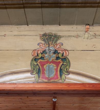 Zdjęcie nr 6: Polichromia ścian kościoła odpowiada podziałom architektonicznym wnętrza wydzielonym przez pilastry. Malowany zielony cokół w jednej czwartej wysokości ścian wyodrębniony jest pasem ornamentu geometrycznego, w nawie w jego polu znajdują się żółte prostokąty z dekoracją geometryczną, w prezbiterium malowana jasnozielona tkanina z dwoma pasami ornamentu roślinnego, medalionami z monogramami Marii i koronami oraz z motywem lilii heraldycznych i rozet. Trzony pilastrów wnętrza bladożółte z malowanymi płycinami dekorowanymi kampanulami, głowice zdobione malowanym kimationem. Na osi pilastrów, w partii fryzu, na tle niebieskich prostokątów uskrzydlone główki anielskie, pomiędzy nimi fryz wypełniony różowo-pomarańczowymi malowanymi płycinami w błękitnym obramieniu o fantazyjnym wykroju, dekorowanymi kampanulami. Belkowanie zamknięte malowanym pasem ornamentu geometrycznego. W polach pomiędzy pilastrami malowane płyciny o fantazyjnym kształcie zbliżonym do prostokąta, ujęte ramą zakończoną kartuszem, ich pola wypełnione są dekoracją geometryczną składającą się z krzyży równoramiennych w glorii i rozet wykonanych techniką patronową. Otwory okienne ujęte są malowanymi, imitującymi profilowanie obramieniami, otwory drzwiowe iluzjonistycznymi portalami z uszakami: portal w nawie zwieńczony jest kartuszem, a portal w prezbiterium zwieńczony jest szczytem zamkniętym fragmentem gzymsu w formie łuku segmentowego nadwieszonego podtrzymywanym przez spływy wolutowe. Pod chórem muzycznym malowane tablice pamiątkowe ujęte ramą, na ścianie północnej z napisem: „Ecclam hanc sub titulo Assumptionis B.V. Mariae a strenuo / milite Wierzbięta in Branice et Ruszcza Haerede pimo in / Wola juxta fines villae Stryjów a D. 1386 fundatam decimis / ex praedio Branice a colonis Stryjów, Wola, cuius sors est Grabie / Szczurów Zymbrzeg et ibidem taberna cum duobus pratis ac lacubus / Orzek et Piotrek ditatam, proper alluviem Vistulae  curatus suus / in hunc locum, qui erat pratum Gruczyn, ecclae dotale transtulit, / Hac tandem post annos 356 collapsa, quam vides, A.R.D. Jacobus Cichoński, parochus Grabiensis a.D. 1742 in loco desolatae  novam erexit. / Consecravit Illmus ac Rmus Michaël Kunicki, Sufraganeus Eppus. / Cracoviensis, Abbas Clarae Tumbae a D. 1749. / Restauravit A.R.D. Josephus Raźny, parochus Grabiensis a.D. 1907. / e colectis parochianorum.”; na ścianie południowej z napisem: „Ku Pamięci! / Dzieci Moje Najmilsze - Ja Prastara Świątynia / Polska dziękuję Wam za serdeczną troskę / o mnie. Oto dzięki Waszym ofiarom Drodzy / Rodzice i Twoim wysiłkom Kochana Młodzieży / w r. 1959 odnowiło się moje oblicze - rozjaśniały /  moje ołtarze, a w r. 1960 zabrzmiał mój nowy / organ na większą chwałę Bożą. Ja Was za to / rodzę na nowo do życia łaski. Ja Was błogosławię / na życie rodzinne. Ja Was prowadzę ku Bogu. Ja / Was także żegnam poraz ostatni, gdy przechodzicie / z tego padołu płaczu do wieczności, aby / Was znowu powitać kiedyś w niebie.”. Na ścianie zachodniej, pod chórem, nad środkowym otworem przejściowym pozostałości dawnego iluzjonistycznego portalu z kartuszem herbowym. Na stropie prezbiterium wydzielone pole o kształcie powtarzającym plan prezbiterium, wewnątrz pole w formie kwadratu o wklęsłych narożach z wpisanym polem o fantazyjnym zarysie zbliżonym do owalu ze sceną Wniebowzięcia Najświętszej Marii Panny. W narożach owalne pola z czterema istotami apokaliptycznymi. Prosta belka tęczowa w kolorze zielonym, o profilowaniach w kolorze niebieskim i różowym, z napisem: „JEZU ZMIŁUJ SIĘ NAD NAMI”. Na stropie nawy prostokątne pole wydzielone grubym bladoróżowym obramieniem z płycinami o nieregularnym kształcie wypełnionymi kratką regencyjną i rozetami alternowanymi medalionami z rozetami, naroża dekorowane są wstęgą regencyjną i akantem. Wewnątrz pole o fantazyjnym wykroju zbliżonym do owalu ze sceną Koronacji Najświętszej Marii Panny, flankowane przez dwie malowane błękitne płyciny o nieregularnym kształcie wypełnione rozetkami. W narożach, w ozdobnych kartuszach herby Pogoni Litewskiej i Orła Białego.
