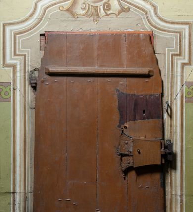 Zdjęcie nr 8: Polichromia ścian kościoła odpowiada podziałom architektonicznym wnętrza wydzielonym przez pilastry. Malowany zielony cokół w jednej czwartej wysokości ścian wyodrębniony jest pasem ornamentu geometrycznego, w nawie w jego polu znajdują się żółte prostokąty z dekoracją geometryczną, w prezbiterium malowana jasnozielona tkanina z dwoma pasami ornamentu roślinnego, medalionami z monogramami Marii i koronami oraz z motywem lilii heraldycznych i rozet. Trzony pilastrów wnętrza bladożółte z malowanymi płycinami dekorowanymi kampanulami, głowice zdobione malowanym kimationem. Na osi pilastrów, w partii fryzu, na tle niebieskich prostokątów uskrzydlone główki anielskie, pomiędzy nimi fryz wypełniony różowo-pomarańczowymi malowanymi płycinami w błękitnym obramieniu o fantazyjnym wykroju, dekorowanymi kampanulami. Belkowanie zamknięte malowanym pasem ornamentu geometrycznego. W polach pomiędzy pilastrami malowane płyciny o fantazyjnym kształcie zbliżonym do prostokąta, ujęte ramą zakończoną kartuszem, ich pola wypełnione są dekoracją geometryczną składającą się z krzyży równoramiennych w glorii i rozet wykonanych techniką patronową. Otwory okienne ujęte są malowanymi, imitującymi profilowanie obramieniami, otwory drzwiowe iluzjonistycznymi portalami z uszakami: portal w nawie zwieńczony jest kartuszem, a portal w prezbiterium zwieńczony jest szczytem zamkniętym fragmentem gzymsu w formie łuku segmentowego nadwieszonego podtrzymywanym przez spływy wolutowe. Pod chórem muzycznym malowane tablice pamiątkowe ujęte ramą, na ścianie północnej z napisem: „Ecclam hanc sub titulo Assumptionis B.V. Mariae a strenuo / milite Wierzbięta in Branice et Ruszcza Haerede pimo in / Wola juxta fines villae Stryjów a D. 1386 fundatam decimis / ex praedio Branice a colonis Stryjów, Wola, cuius sors est Grabie / Szczurów Zymbrzeg et ibidem taberna cum duobus pratis ac lacubus / Orzek et Piotrek ditatam, proper alluviem Vistulae  curatus suus / in hunc locum, qui erat pratum Gruczyn, ecclae dotale transtulit, / Hac tandem post annos 356 collapsa, quam vides, A.R.D. Jacobus Cichoński, parochus Grabiensis a.D. 1742 in loco desolatae  novam erexit. / Consecravit Illmus ac Rmus Michaël Kunicki, Sufraganeus Eppus. / Cracoviensis, Abbas Clarae Tumbae a D. 1749. / Restauravit A.R.D. Josephus Raźny, parochus Grabiensis a.D. 1907. / e colectis parochianorum.”; na ścianie południowej z napisem: „Ku Pamięci! / Dzieci Moje Najmilsze - Ja Prastara Świątynia / Polska dziękuję Wam za serdeczną troskę / o mnie. Oto dzięki Waszym ofiarom Drodzy / Rodzice i Twoim wysiłkom Kochana Młodzieży / w r. 1959 odnowiło się moje oblicze - rozjaśniały /  moje ołtarze, a w r. 1960 zabrzmiał mój nowy / organ na większą chwałę Bożą. Ja Was za to / rodzę na nowo do życia łaski. Ja Was błogosławię / na życie rodzinne. Ja Was prowadzę ku Bogu. Ja / Was także żegnam poraz ostatni, gdy przechodzicie / z tego padołu płaczu do wieczności, aby / Was znowu powitać kiedyś w niebie.”. Na ścianie zachodniej, pod chórem, nad środkowym otworem przejściowym pozostałości dawnego iluzjonistycznego portalu z kartuszem herbowym. Na stropie prezbiterium wydzielone pole o kształcie powtarzającym plan prezbiterium, wewnątrz pole w formie kwadratu o wklęsłych narożach z wpisanym polem o fantazyjnym zarysie zbliżonym do owalu ze sceną Wniebowzięcia Najświętszej Marii Panny. W narożach owalne pola z czterema istotami apokaliptycznymi. Prosta belka tęczowa w kolorze zielonym, o profilowaniach w kolorze niebieskim i różowym, z napisem: „JEZU ZMIŁUJ SIĘ NAD NAMI”. Na stropie nawy prostokątne pole wydzielone grubym bladoróżowym obramieniem z płycinami o nieregularnym kształcie wypełnionymi kratką regencyjną i rozetami alternowanymi medalionami z rozetami, naroża dekorowane są wstęgą regencyjną i akantem. Wewnątrz pole o fantazyjnym wykroju zbliżonym do owalu ze sceną Koronacji Najświętszej Marii Panny, flankowane przez dwie malowane błękitne płyciny o nieregularnym kształcie wypełnione rozetkami. W narożach, w ozdobnych kartuszach herby Pogoni Litewskiej i Orła Białego.
