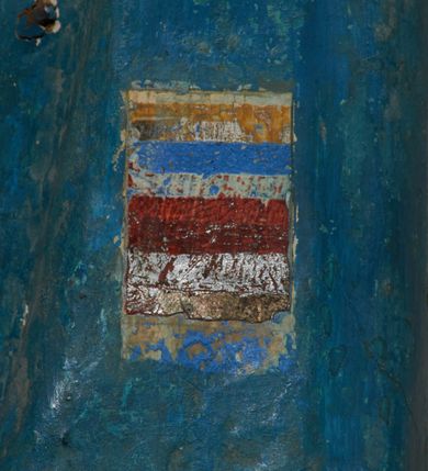 Zdjęcie nr 36: Ołtarz prostopadłościenny, murowany, w drewnianej obudowie, z drewnianą mensą. Antependium w kształcie leżącego prostokąta ujętego profilowaną ramą, dekorowane monogramem imienia MARIA w środku pola i symetrycznie rozłożonymi po bokach różanymi gałązkami. Na mensie ustawione architektoniczne tabernakulum. 
Nastawa w formie paludamentu podwiązanego po bokach sznurem z chwostami, lamowanego frędzlą, zwieńczonego baldachimem utworzonym z fragmentu wklęsło-wypukłego gzymsu z lambrekinem i rokokowym kartuszem. W polu paludamentu wnęka w kształcie stojącego prostokąta o wklęsłych górnych narożach w profilowanej ramie, ustawiona na cokole ujętym spływami wolutowymi. Wewnątrz obraz Matki Boskiej z Dzieciątkiem ujęty grubą ramą dekorowaną akantem i palmetami, ponad nim uskrzydlona główka anielska. Wnękę flankują dwa unoszące się putta, powyżej niej kartusz z monogramem Marii. Paludament dekorowany plastycznymi gwiazdami. Po bokach nastawy dwie bramki z otworami wejściowymi w formie stojącego prostokąta, zamkniętymi prostym gzymsem ze znajdującymi się powyżej postumentami dekorowanymi różami, na których stoją dwie figury aniołów. W górnej części, z obydwu stron nastawy poziome listwy konstrukcyjne mocujące całość retabulum do ścian bocznych prezbiterium, dekorowane są uskrzydlonymi główkami anielskimi z muszlami oraz roślinnymi festonami. Paludament polichromowany wewnątrz na biało, zewnątrz na niebiesko z pozłacanymi detalami.

