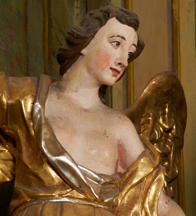 Zdjęcie nr 71: Ołtarz prostopadłościenny, murowany, w drewnianej obudowie, z drewnianą mensą. Antependium w kształcie leżącego prostokąta ujętego profilowaną ramą, dekorowane monogramem imienia MARIA w środku pola i symetrycznie rozłożonymi po bokach różanymi gałązkami. Na mensie ustawione architektoniczne tabernakulum. 
Nastawa w formie paludamentu podwiązanego po bokach sznurem z chwostami, lamowanego frędzlą, zwieńczonego baldachimem utworzonym z fragmentu wklęsło-wypukłego gzymsu z lambrekinem i rokokowym kartuszem. W polu paludamentu wnęka w kształcie stojącego prostokąta o wklęsłych górnych narożach w profilowanej ramie, ustawiona na cokole ujętym spływami wolutowymi. Wewnątrz obraz Matki Boskiej z Dzieciątkiem ujęty grubą ramą dekorowaną akantem i palmetami, ponad nim uskrzydlona główka anielska. Wnękę flankują dwa unoszące się putta, powyżej niej kartusz z monogramem Marii. Paludament dekorowany plastycznymi gwiazdami. Po bokach nastawy dwie bramki z otworami wejściowymi w formie stojącego prostokąta, zamkniętymi prostym gzymsem ze znajdującymi się powyżej postumentami dekorowanymi różami, na których stoją dwie figury aniołów. W górnej części, z obydwu stron nastawy poziome listwy konstrukcyjne mocujące całość retabulum do ścian bocznych prezbiterium, dekorowane są uskrzydlonymi główkami anielskimi z muszlami oraz roślinnymi festonami. Paludament polichromowany wewnątrz na biało, zewnątrz na niebiesko z pozłacanymi detalami.

