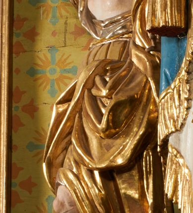 Zdjęcie nr 67: Ołtarz prostopadłościenny, murowany, w drewnianej obudowie, z drewnianą mensą. Antependium w kształcie leżącego prostokąta ujętego profilowaną ramą, dekorowane monogramem imienia MARIA w środku pola i symetrycznie rozłożonymi po bokach różanymi gałązkami. Na mensie ustawione architektoniczne tabernakulum. 
Nastawa w formie paludamentu podwiązanego po bokach sznurem z chwostami, lamowanego frędzlą, zwieńczonego baldachimem utworzonym z fragmentu wklęsło-wypukłego gzymsu z lambrekinem i rokokowym kartuszem. W polu paludamentu wnęka w kształcie stojącego prostokąta o wklęsłych górnych narożach w profilowanej ramie, ustawiona na cokole ujętym spływami wolutowymi. Wewnątrz obraz Matki Boskiej z Dzieciątkiem ujęty grubą ramą dekorowaną akantem i palmetami, ponad nim uskrzydlona główka anielska. Wnękę flankują dwa unoszące się putta, powyżej niej kartusz z monogramem Marii. Paludament dekorowany plastycznymi gwiazdami. Po bokach nastawy dwie bramki z otworami wejściowymi w formie stojącego prostokąta, zamkniętymi prostym gzymsem ze znajdującymi się powyżej postumentami dekorowanymi różami, na których stoją dwie figury aniołów. W górnej części, z obydwu stron nastawy poziome listwy konstrukcyjne mocujące całość retabulum do ścian bocznych prezbiterium, dekorowane są uskrzydlonymi główkami anielskimi z muszlami oraz roślinnymi festonami. Paludament polichromowany wewnątrz na biało, zewnątrz na niebiesko z pozłacanymi detalami.

